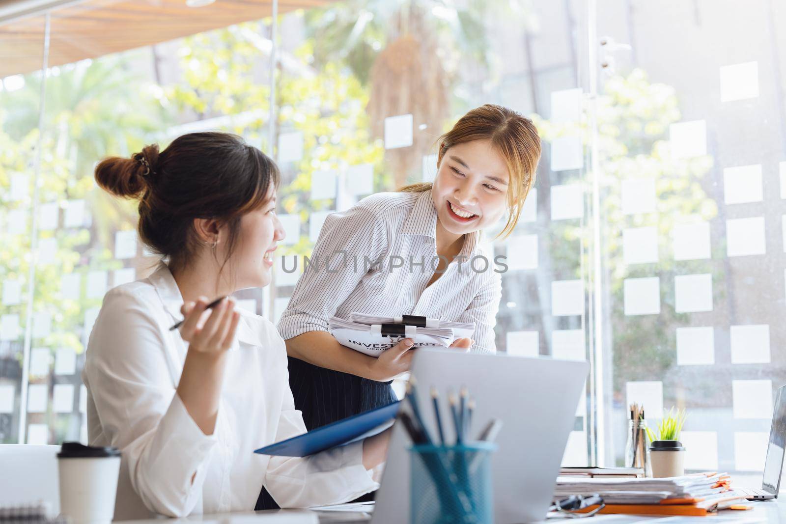 Negotiation, Analysis, Discussion: Portrait of an Asian woman economist and marketer pointing to a financial data sheet to plan investments to prevent risks and losses for the company by Manastrong