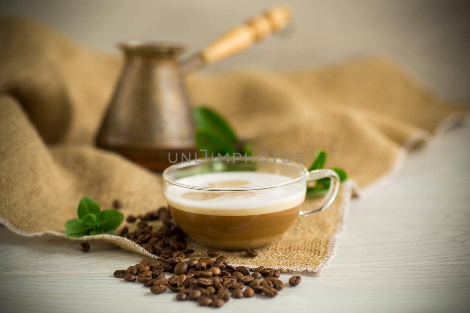 Cup of coffee latte with heart shape and coffee beans on old wooden background