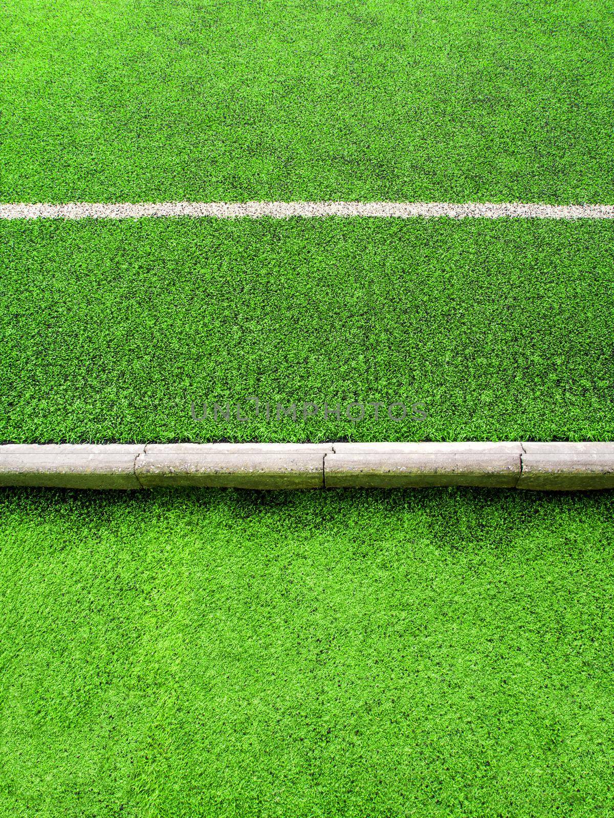 White line on plastic artificial grass and the concrete border of school yard, Artificial grass texture