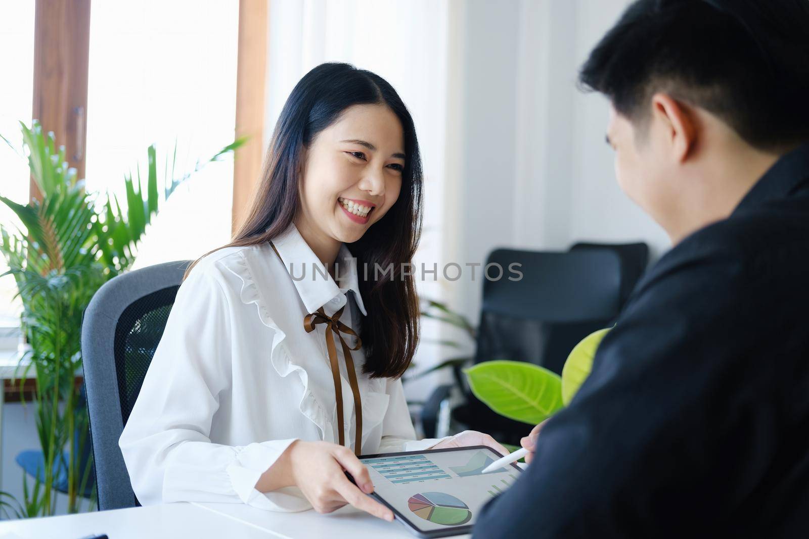 Negotiation, Analysis, Discussion,female economist and male marketer using tablet computer to plan investments and financial to prevent risks and losses for the company.