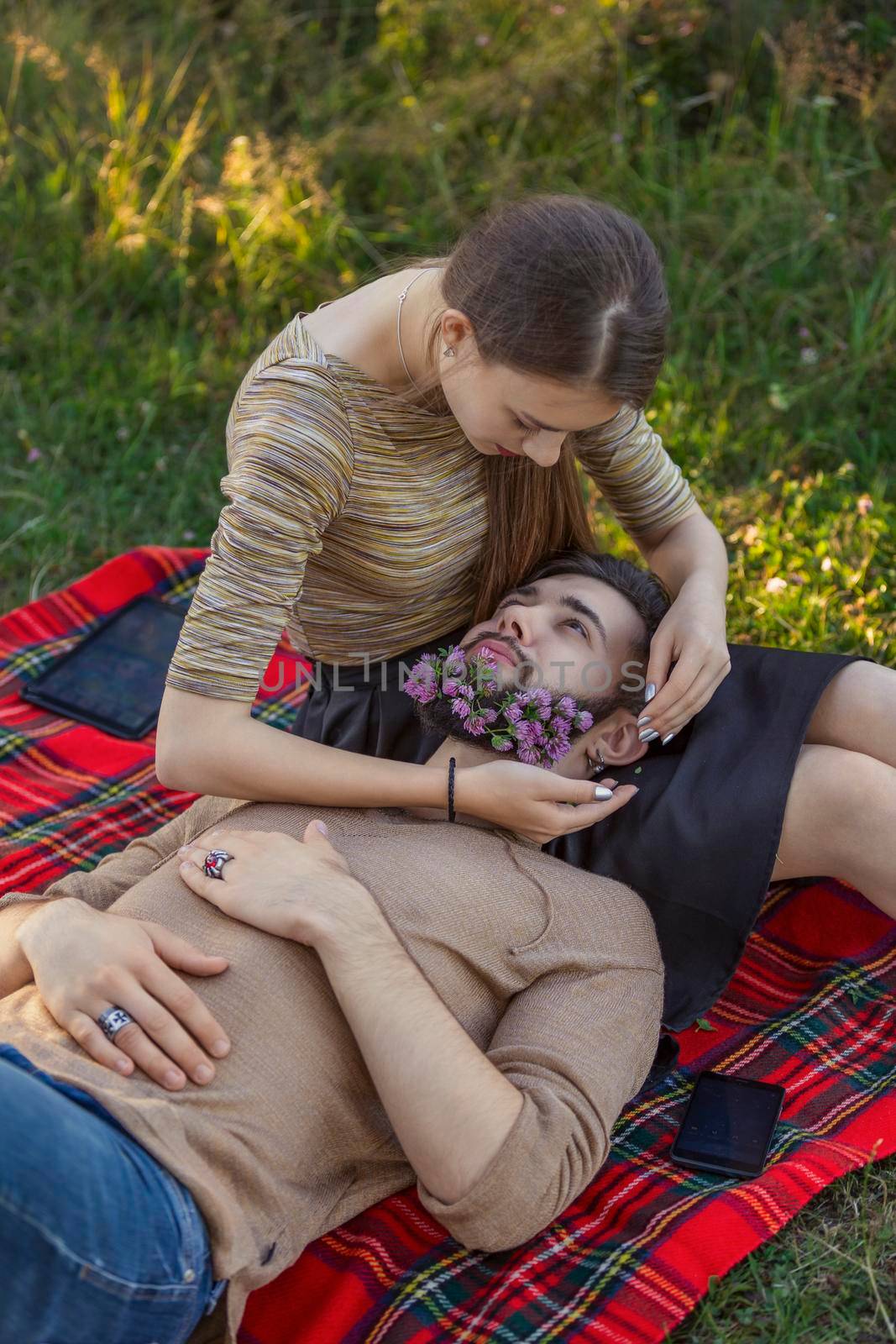 woman with a man in whose beard flowers in nature