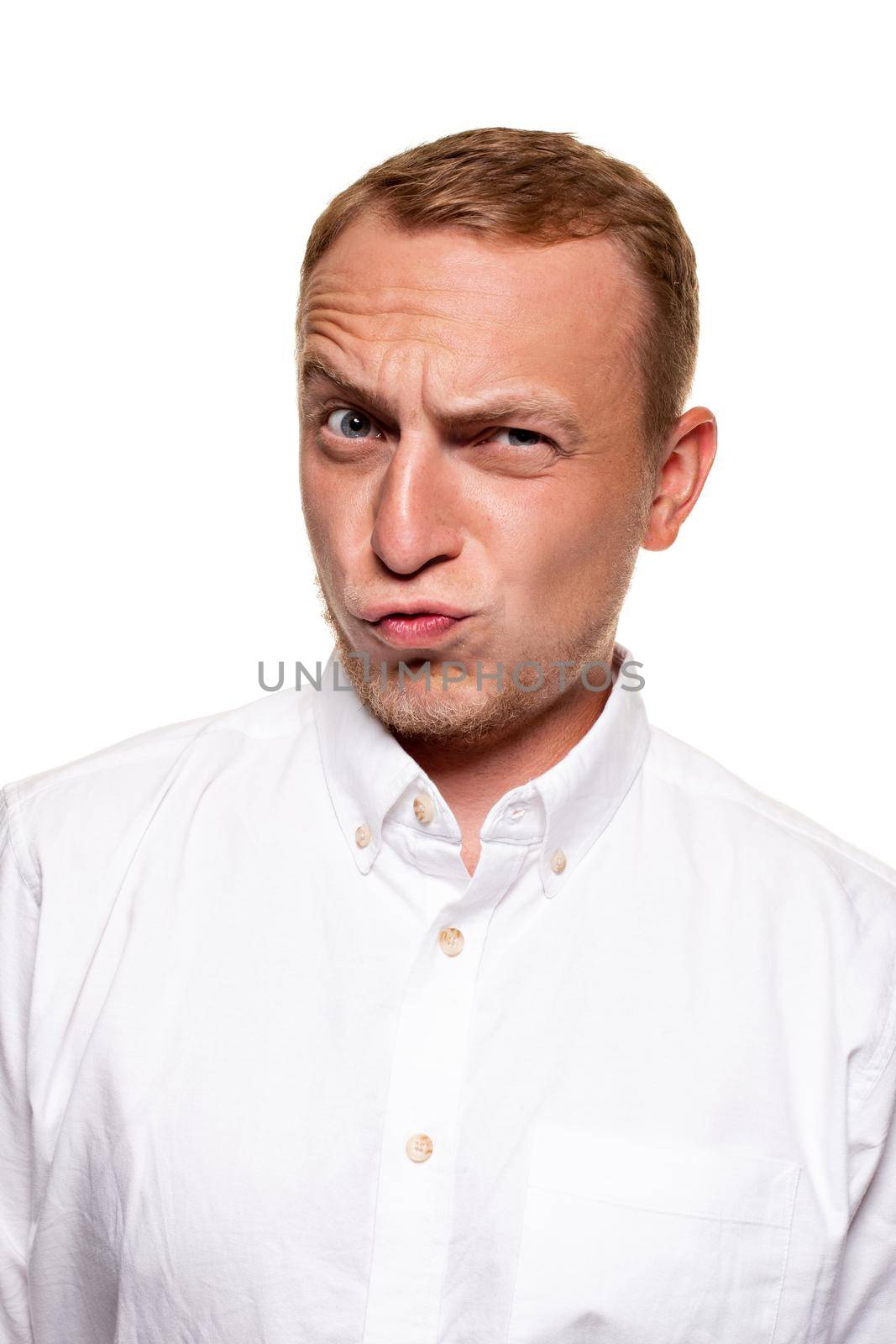 Funny young blond man in a white shirt is grining, isolated on a white background