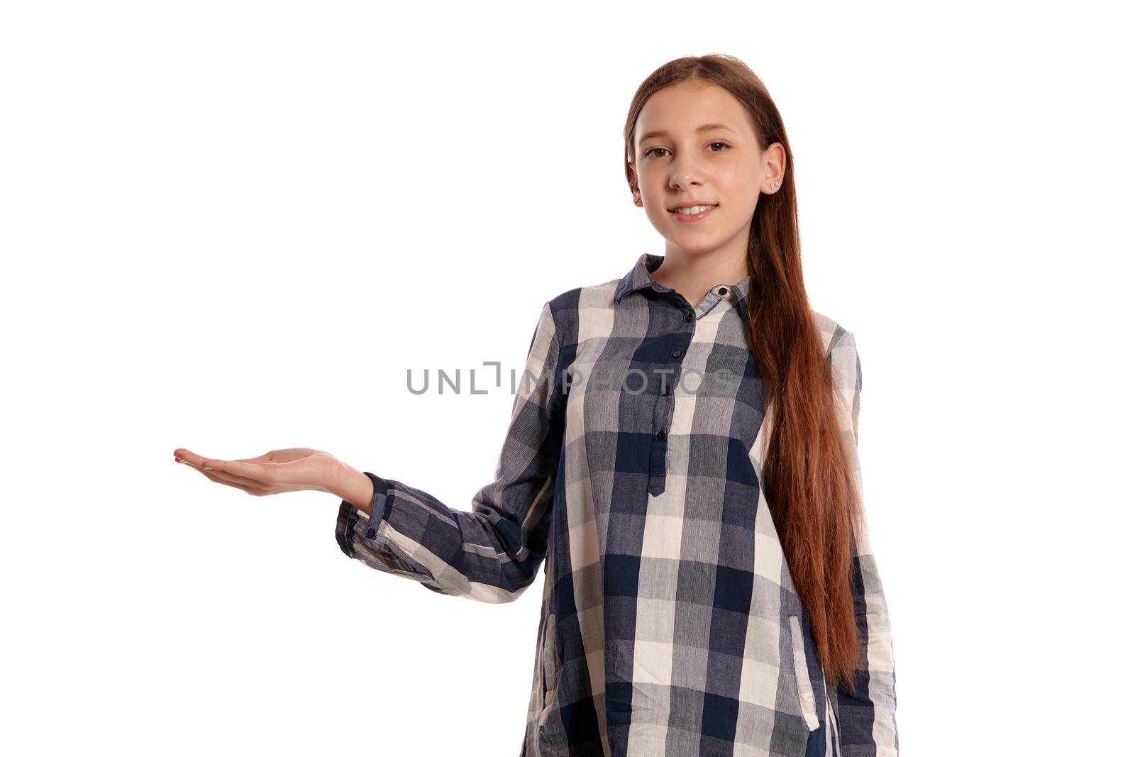 Portrait of a lovely teenager in a casual checkered shirt acting like holding something while posing isolated on white studio background. Long hair, healthy clean skin and brown eyes. Sincere emotions concept. Copy space.