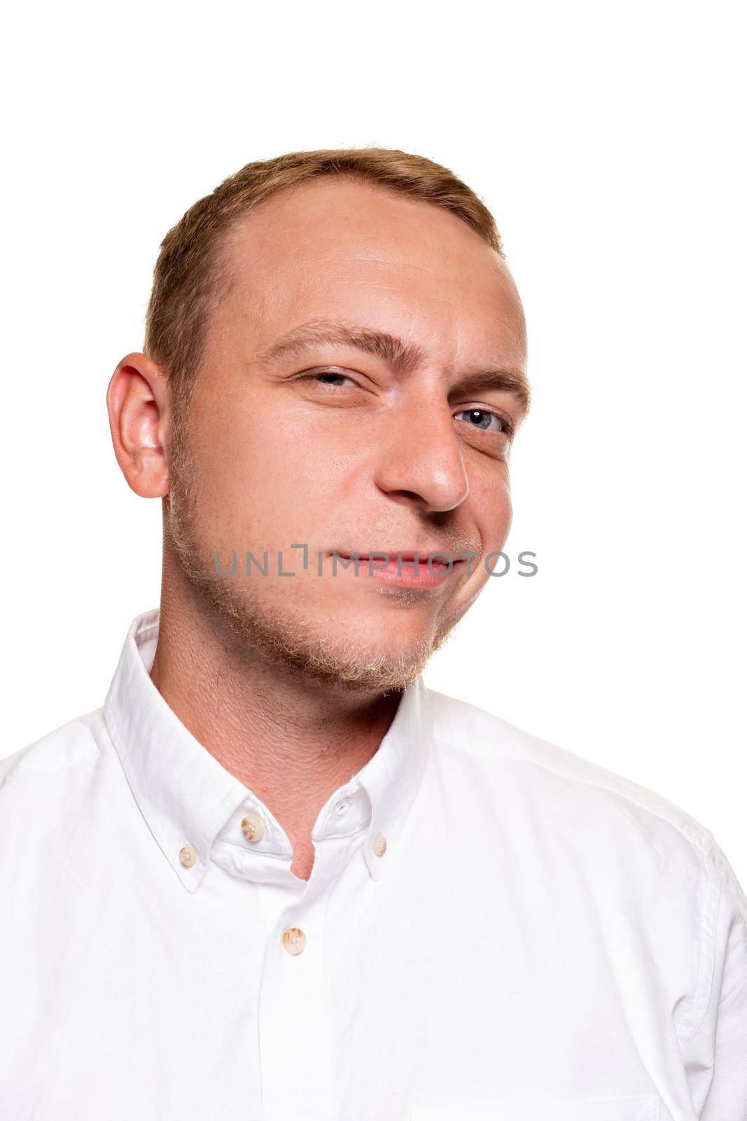 Handsome young blond man in a white shirt is grining, isolated on a white background