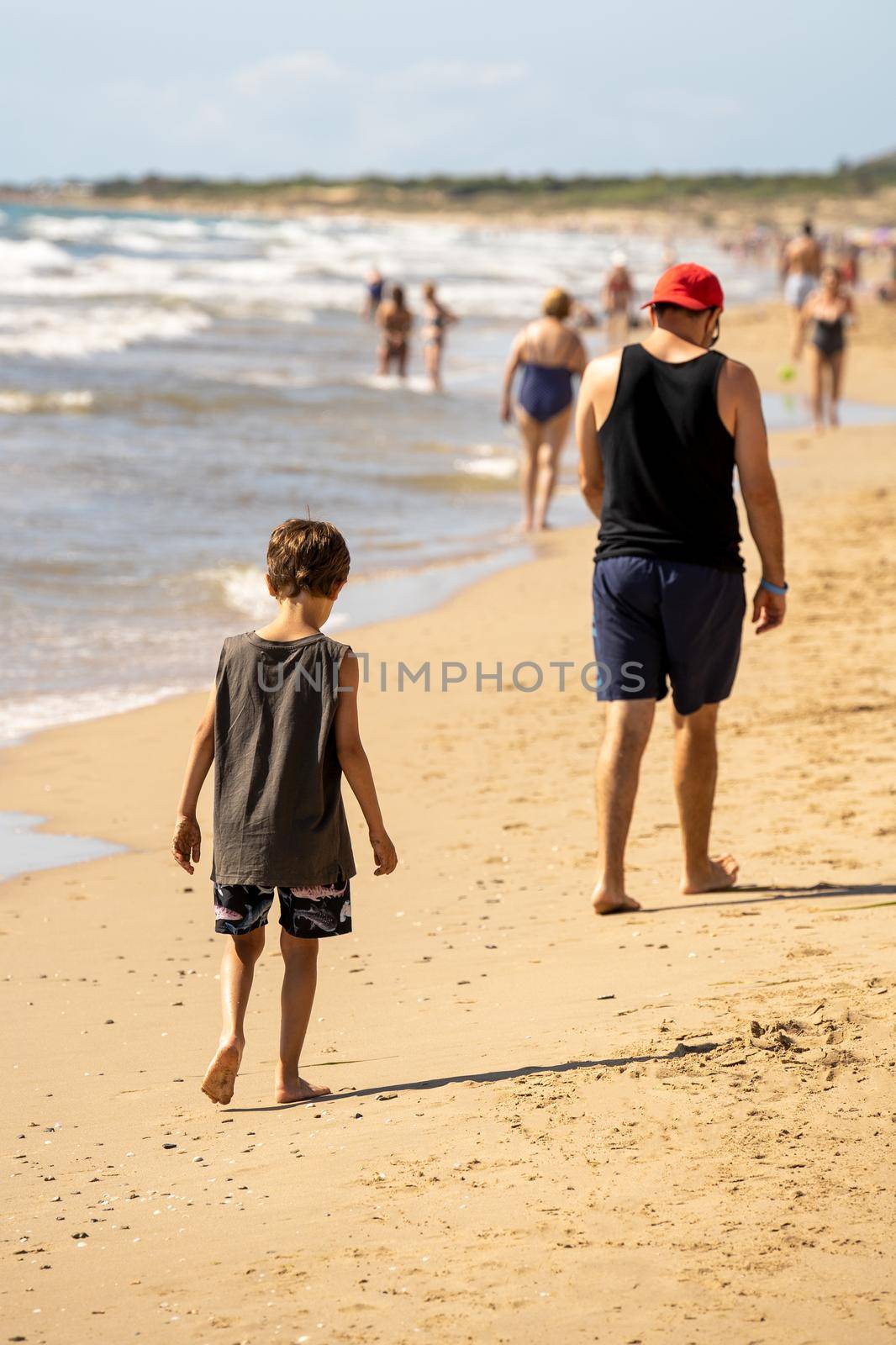 Father and son having fun on tropical white sand beach. Happy family on the beach. People having fun on summer vacation. Childhood. Child playing. Sea background. Fashion photo. Happy day. Travel. by Mareno