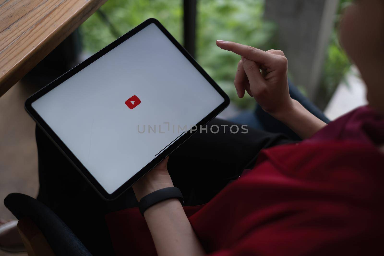 Chiang mai, Thailand - AUG 09, 2021 : Woman using a tablet to connect to YouTube Premium. YouTube is a video-sharing website by google by itchaznong