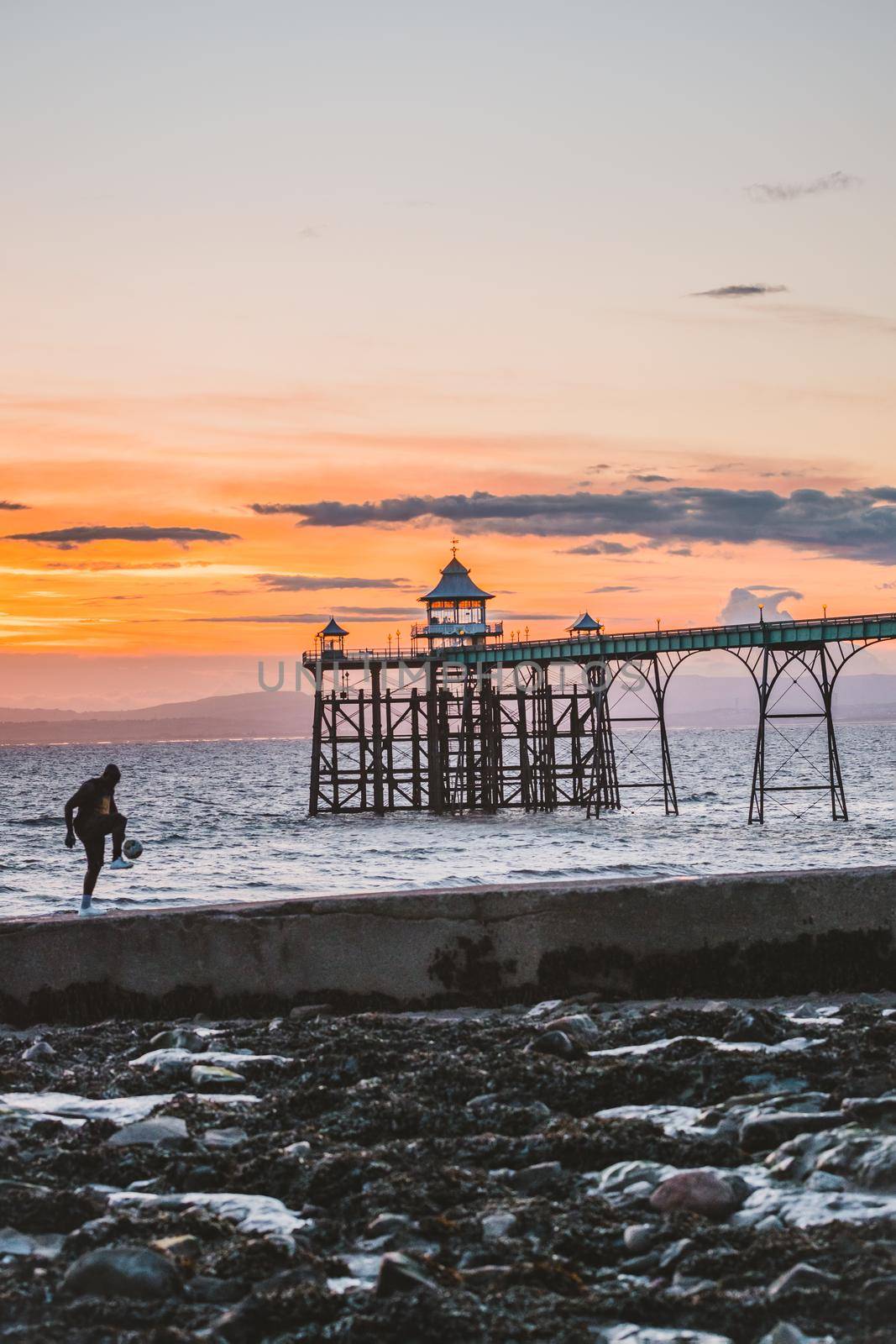 Man playing football in the beach at sunset time. by fabioxavierphotography