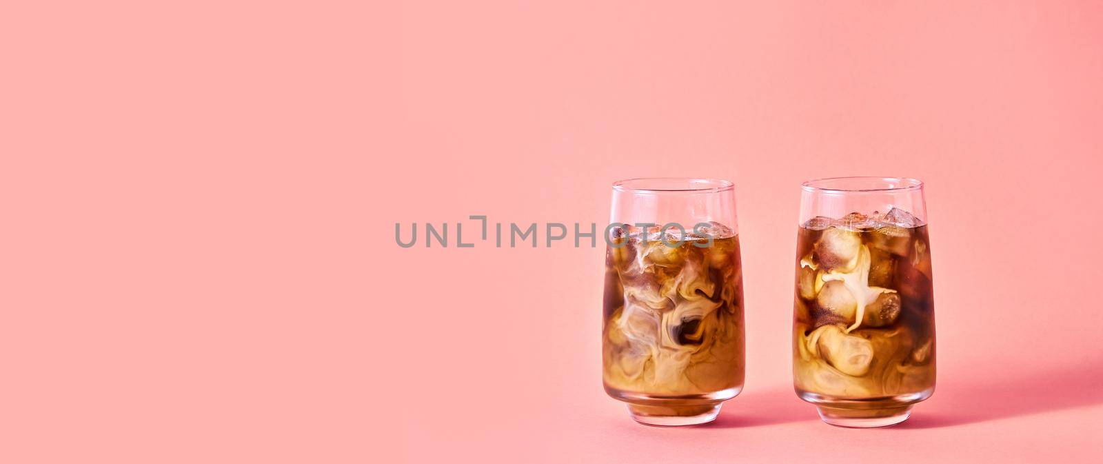 Iced Coffee with Milk in Tall Glasses on Pink Background. Concept Refreshing Summer Drink.