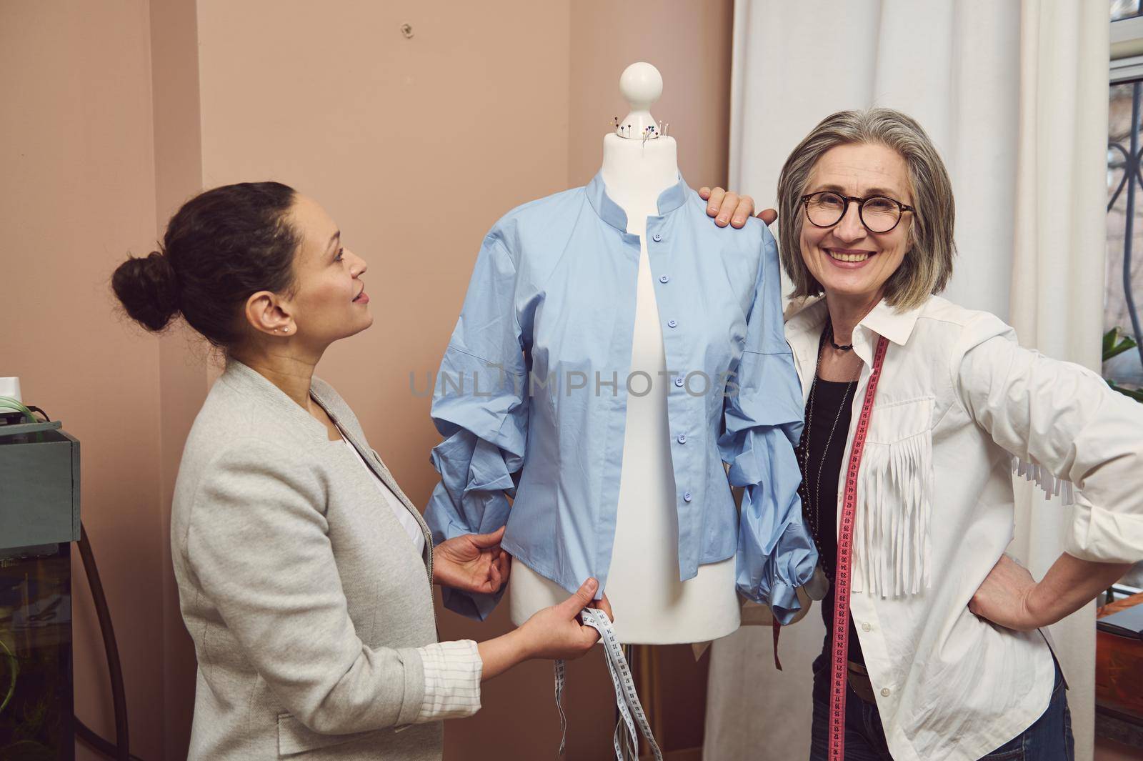 Fashion designers working with a mannequin in fashion design atelier. Tailoring, creation of new garment collection, fashion designer business start-up concept