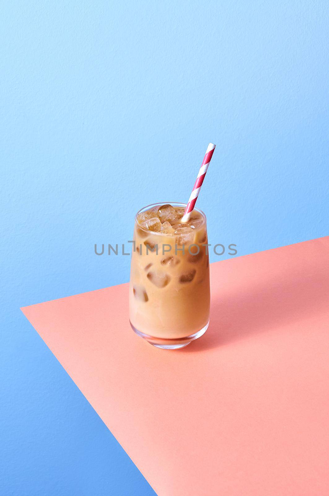 Iced Coffee with Milk in Tall Glasses on Pink Table and Blue Background. Isometric Vertical Orientation.