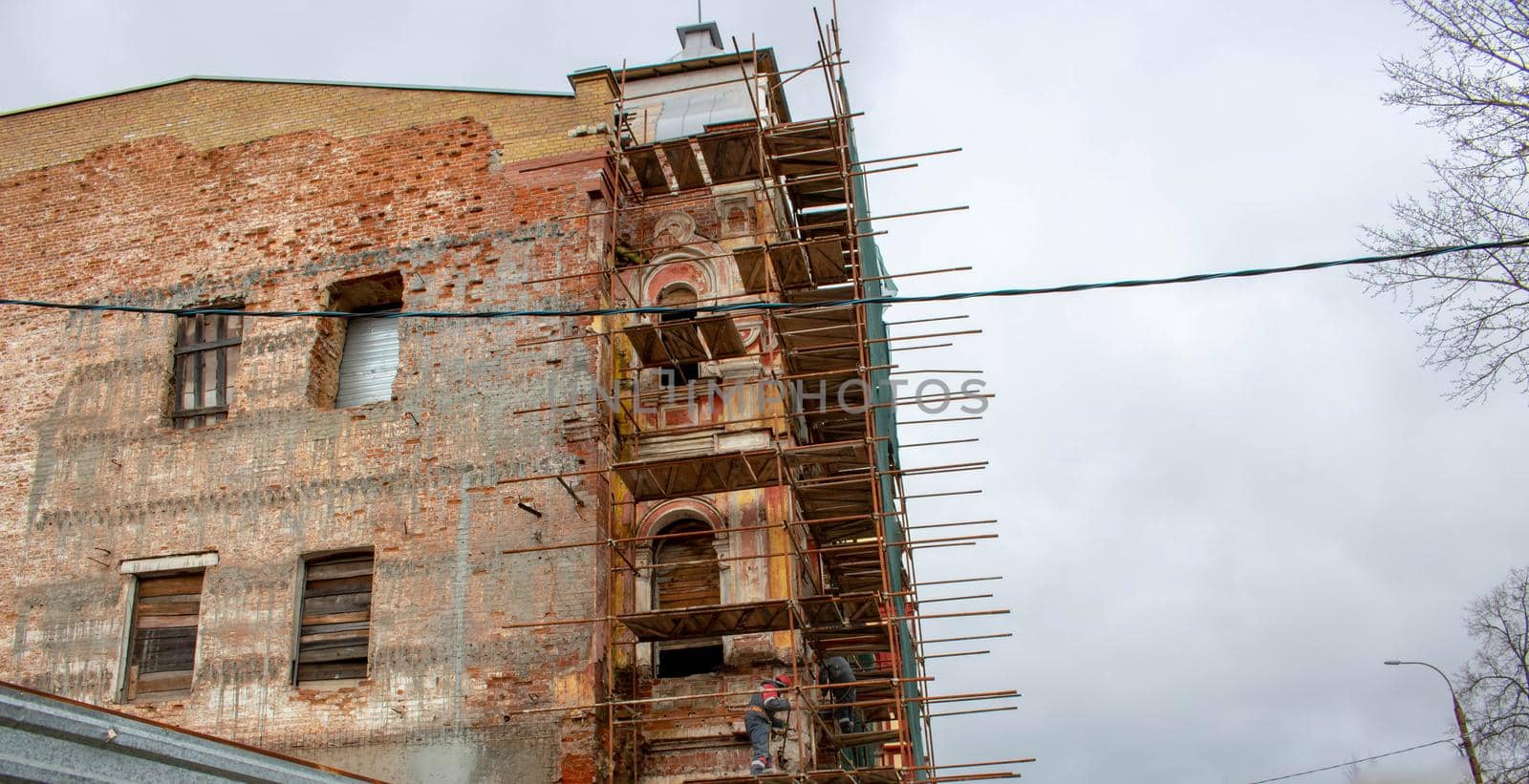 Building facade renovation, old house reconstruction, repair. Scaffold in front of building facade by lapushka62