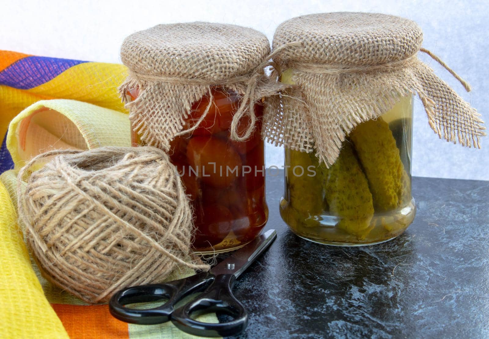 Marinated cucumbers with tomatoes are located in glass jar on a white background. Harvest for the winter. by lapushka62