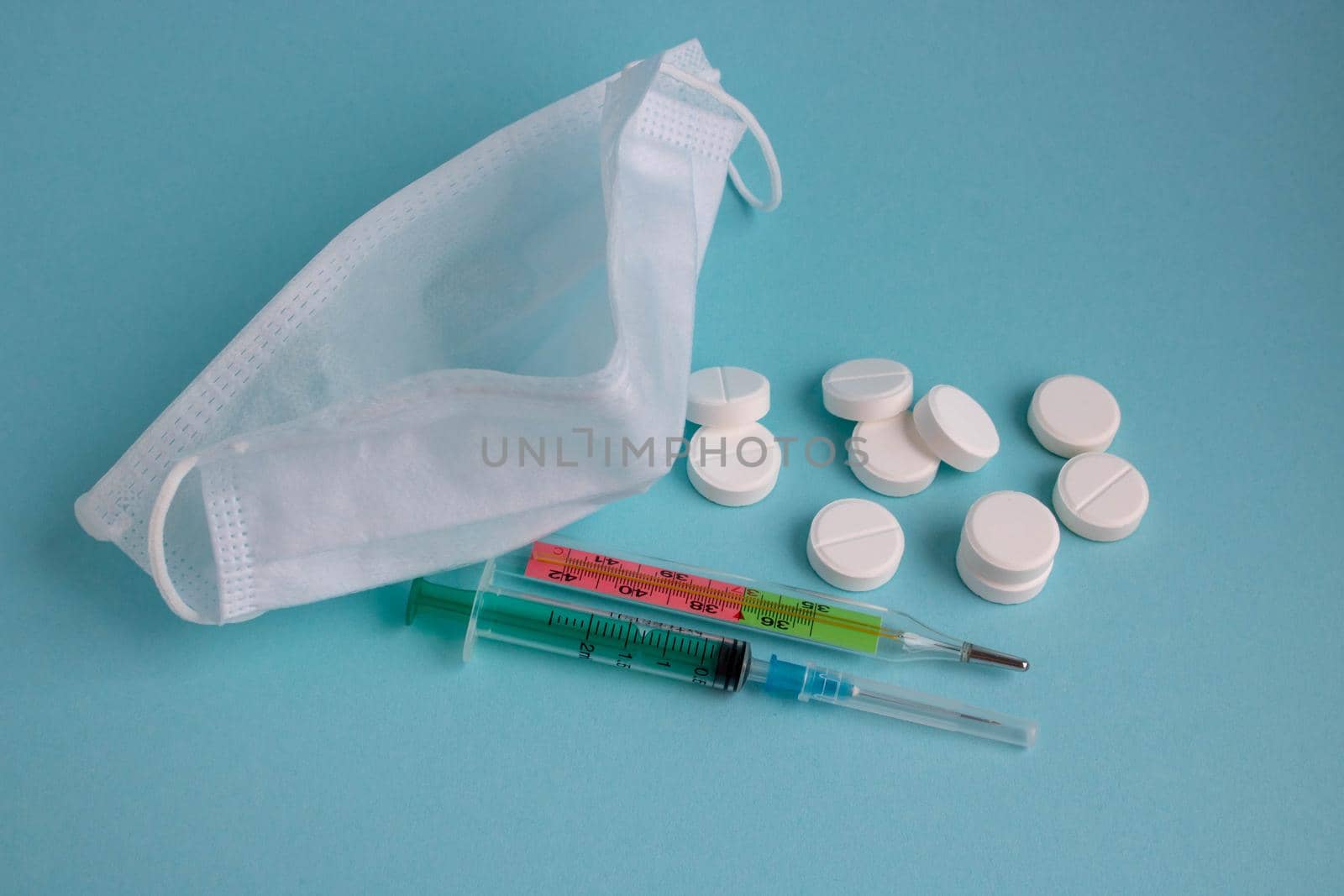 anti-virus medical supplies. concept of deadly coronavirus epidemic. thermometer, mask, syringe with vaccine and antibiotic pills by lapushka62