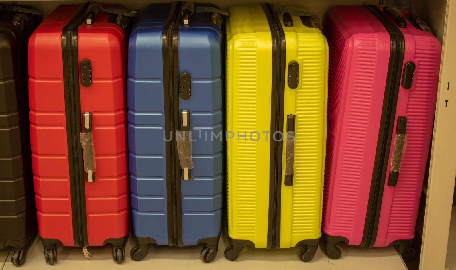Colourful suitcases put in front of the shop. Suitcases that people on vacation often buy. Ready-to-sell suitcases in front of the store
