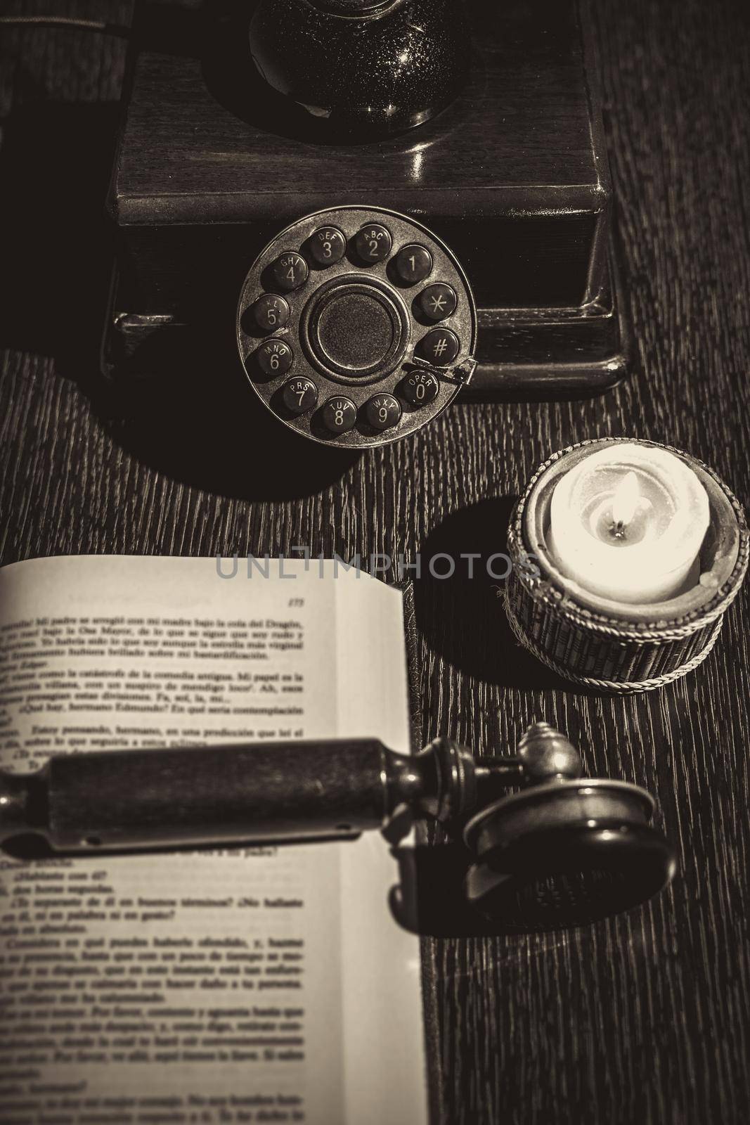 old phone on wooden table with book by Mareno