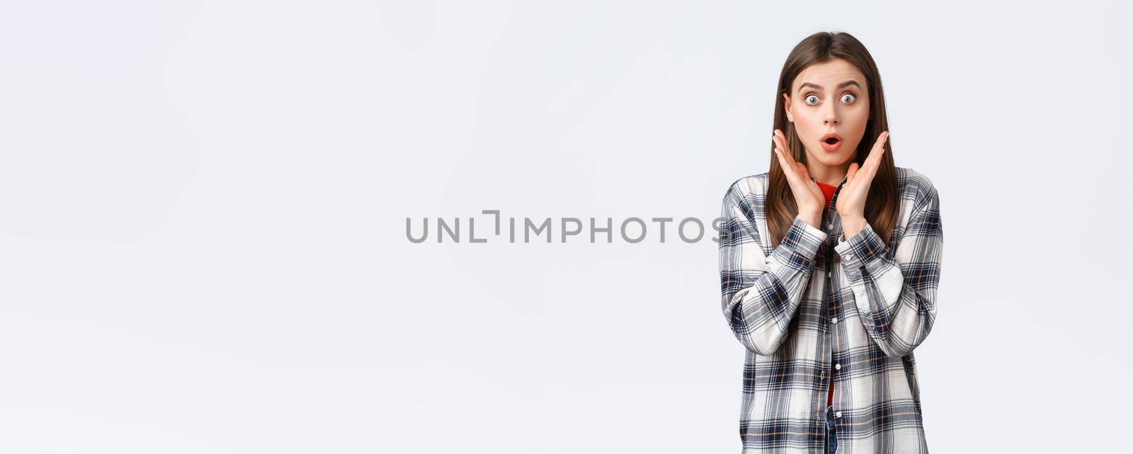 Lifestyle, different emotions, leisure activities concept. Shocked and gasping, startled young caucasian girl in casual outfit, drop jaw, gossiping, say wow and staring amazed camera by Benzoix