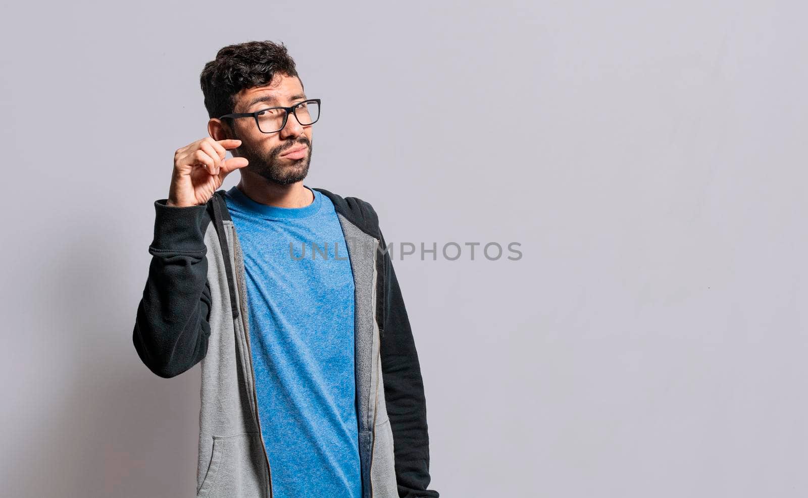 Person showing a small amount with his fingers, people gesturing with his hand showing something small size with his fingers. man measuring something with fingers