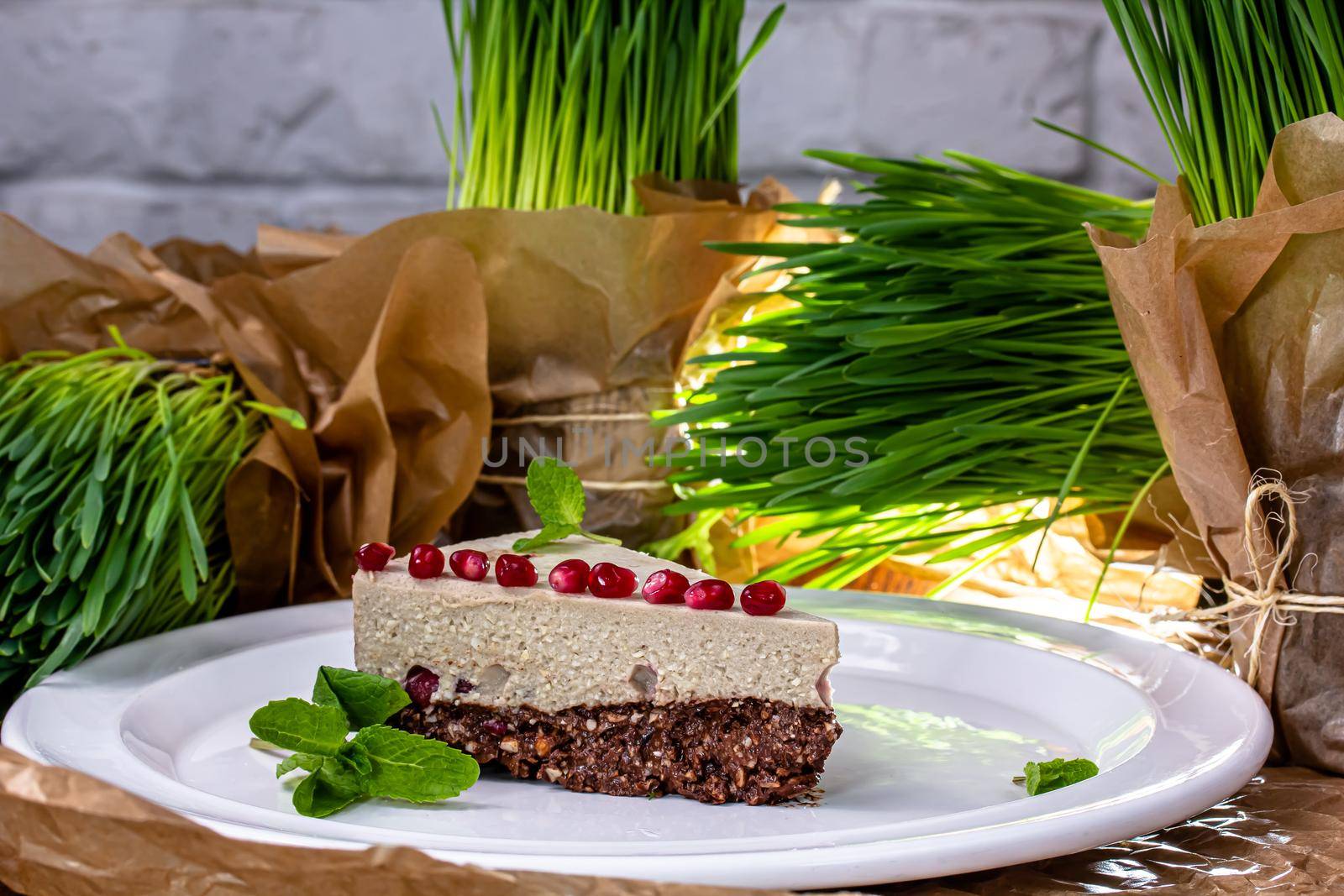 raw vegan cake with fruits and seeds, decorated with flowers, product photography for patisserie by Milanchikov