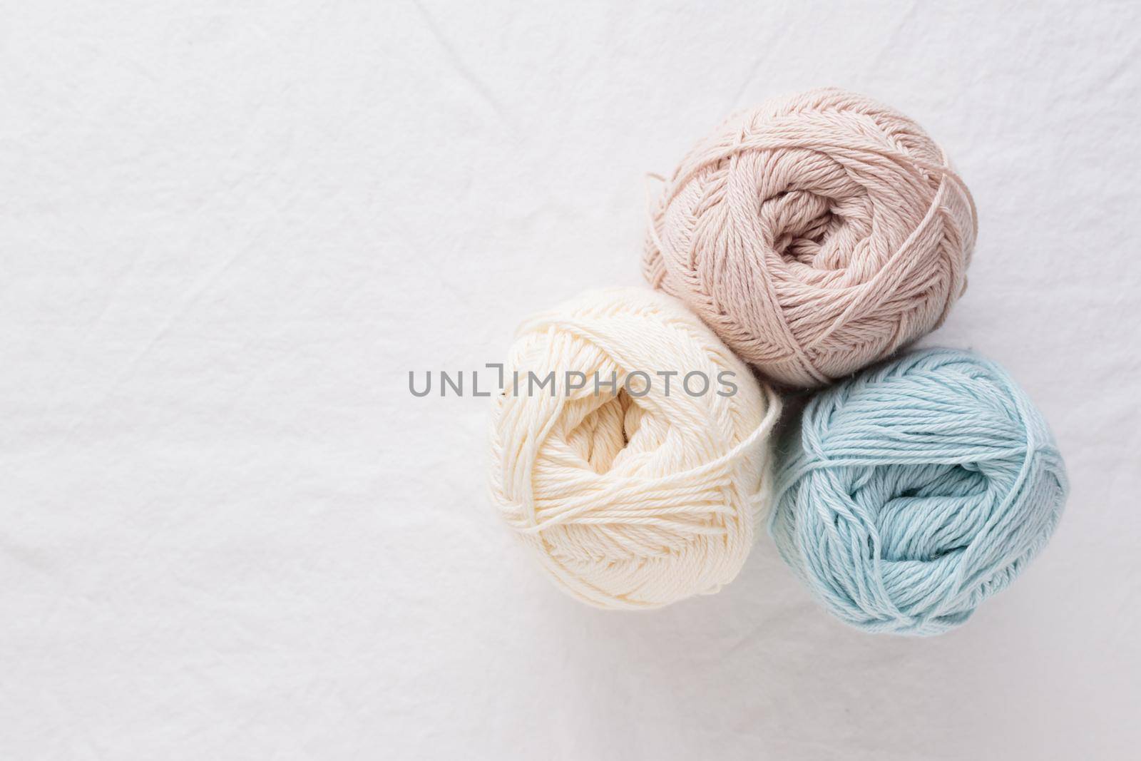 Needlework. Balls of cotton yarn pastel colors on a white table, copy space