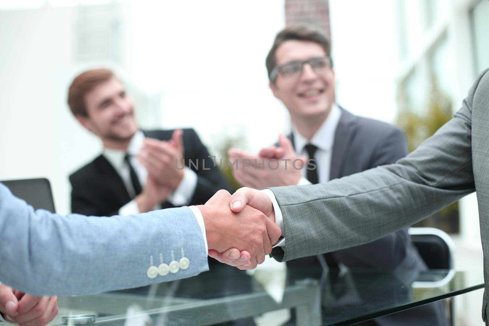 handshake of business people on a blurred office background. by asdf