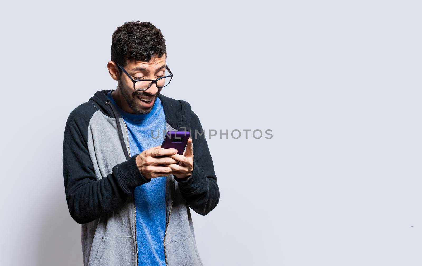 Person smiling and using cell phone isolated, person in glasses smiling using smartphone on isolated background, guy in glasses smiling at cell phone isolated