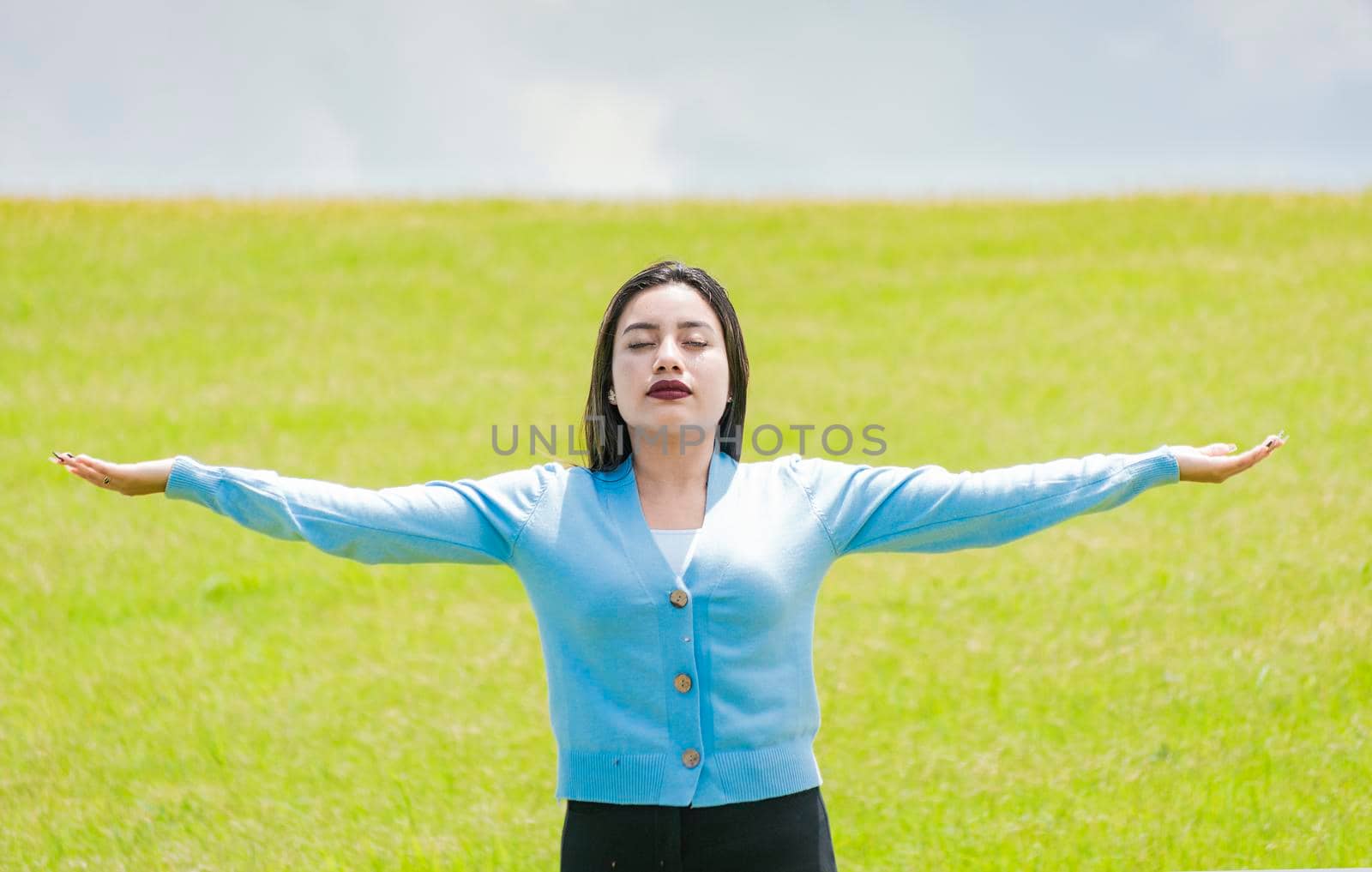 A girl spreading her arms in the field, Attractive young woman spreading her arms in the field, concept of free woman spreading her hands