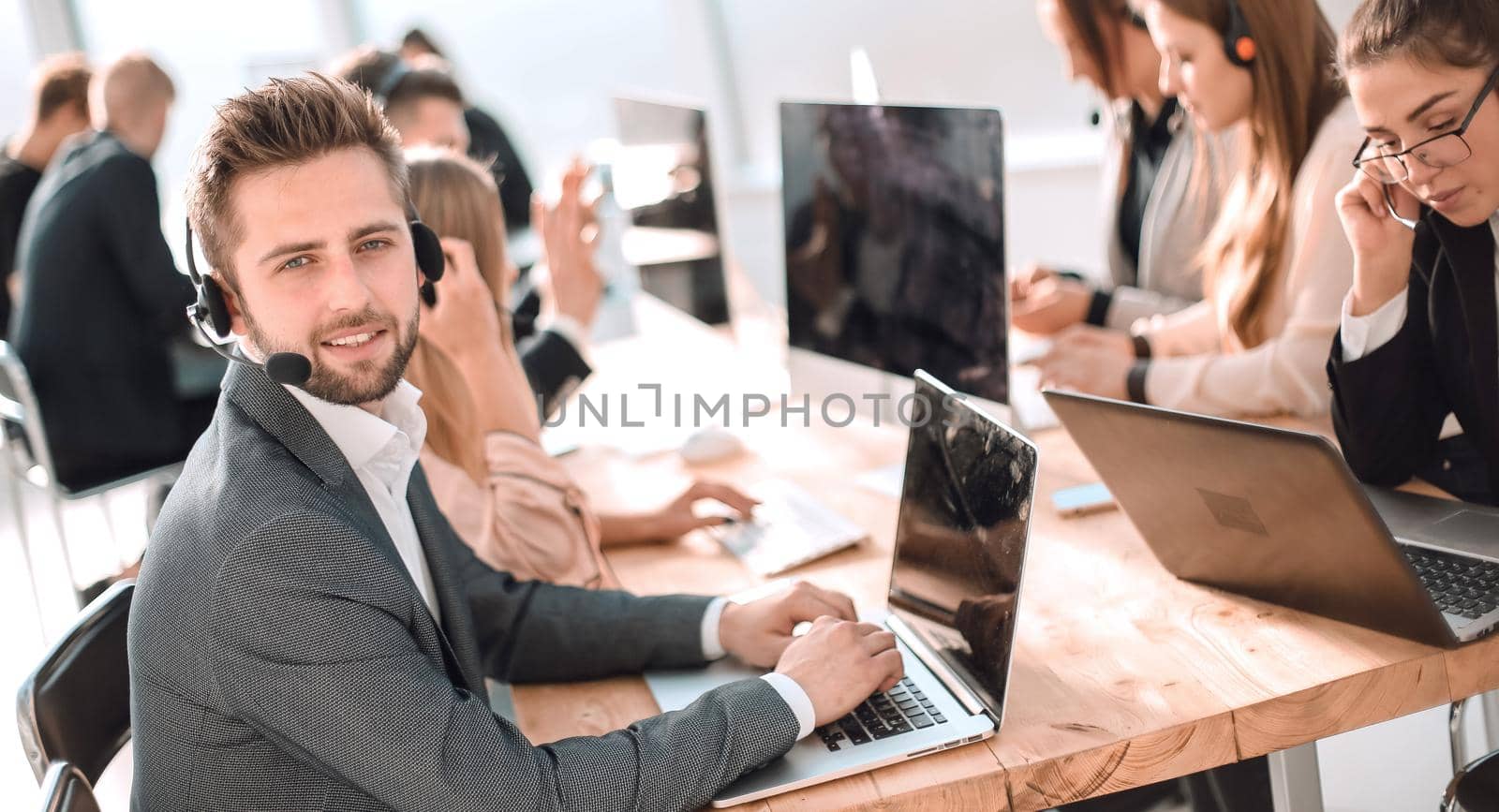 young customer service representative sitting behind a Desk. photo with copy-space