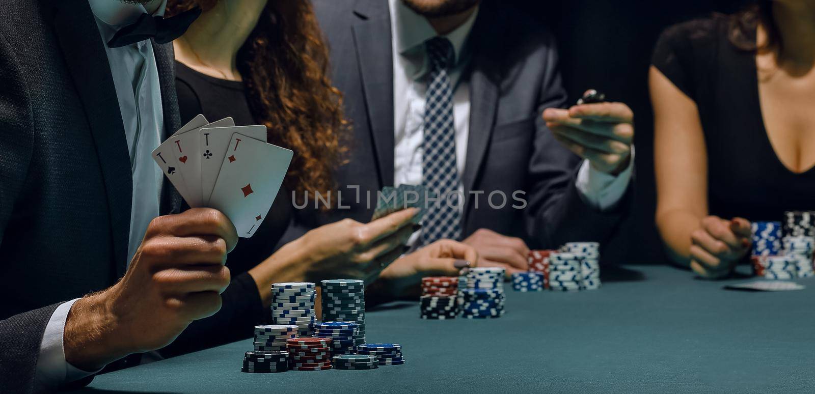 handsome man with cards in the background of the playing table in the casino.