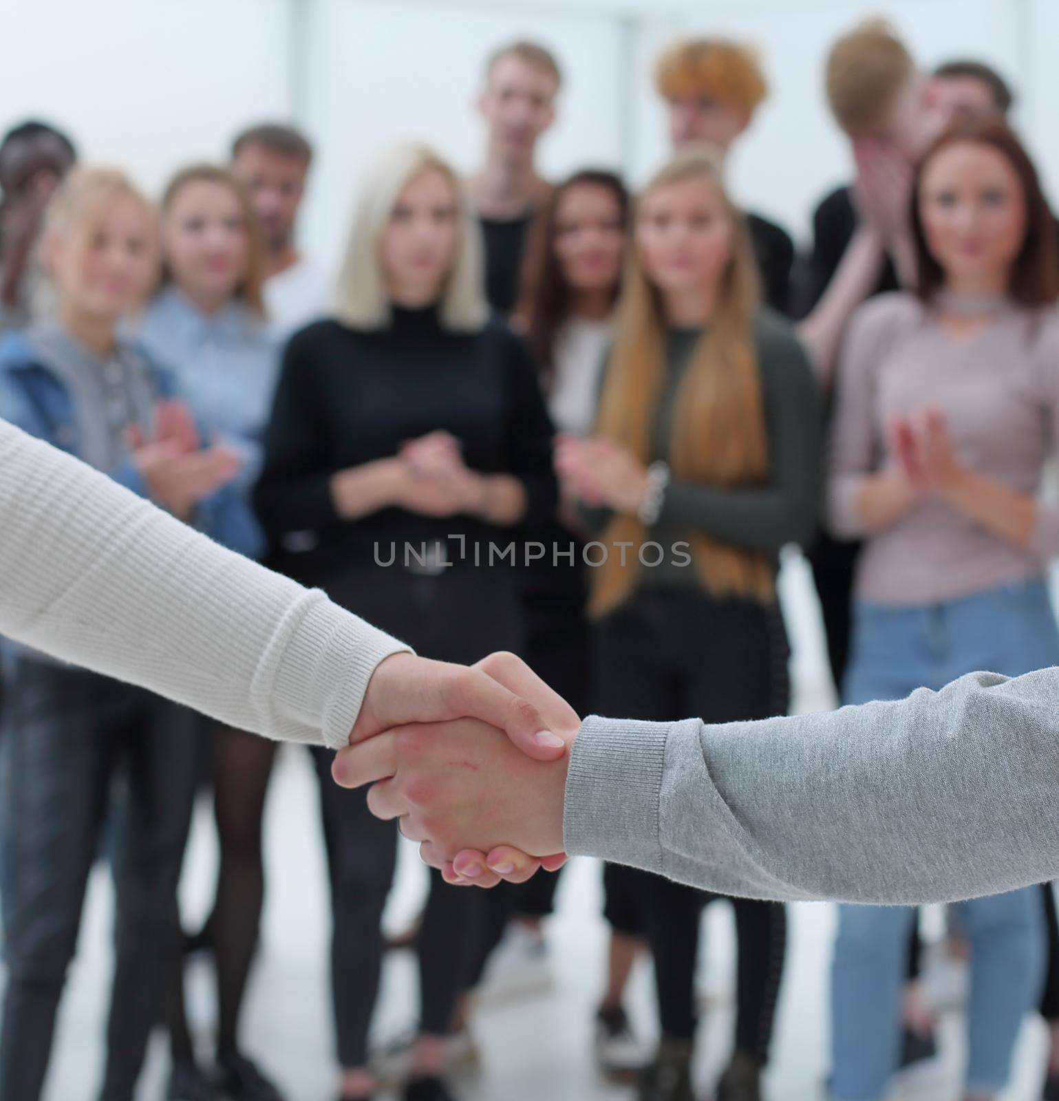 close up. young business people shaking hands with each other. the concept of cooperation