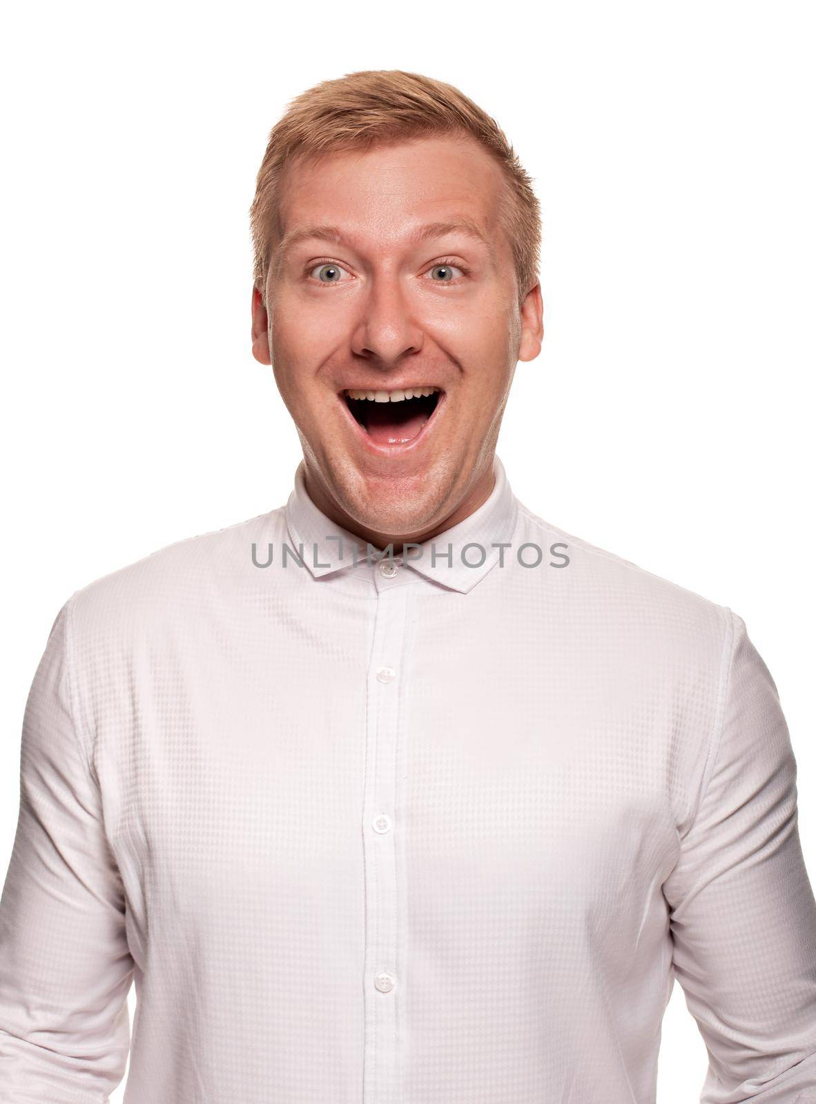 Imposing, young, blond man in a white shirt is looking very happy, while standing isolated on a white background