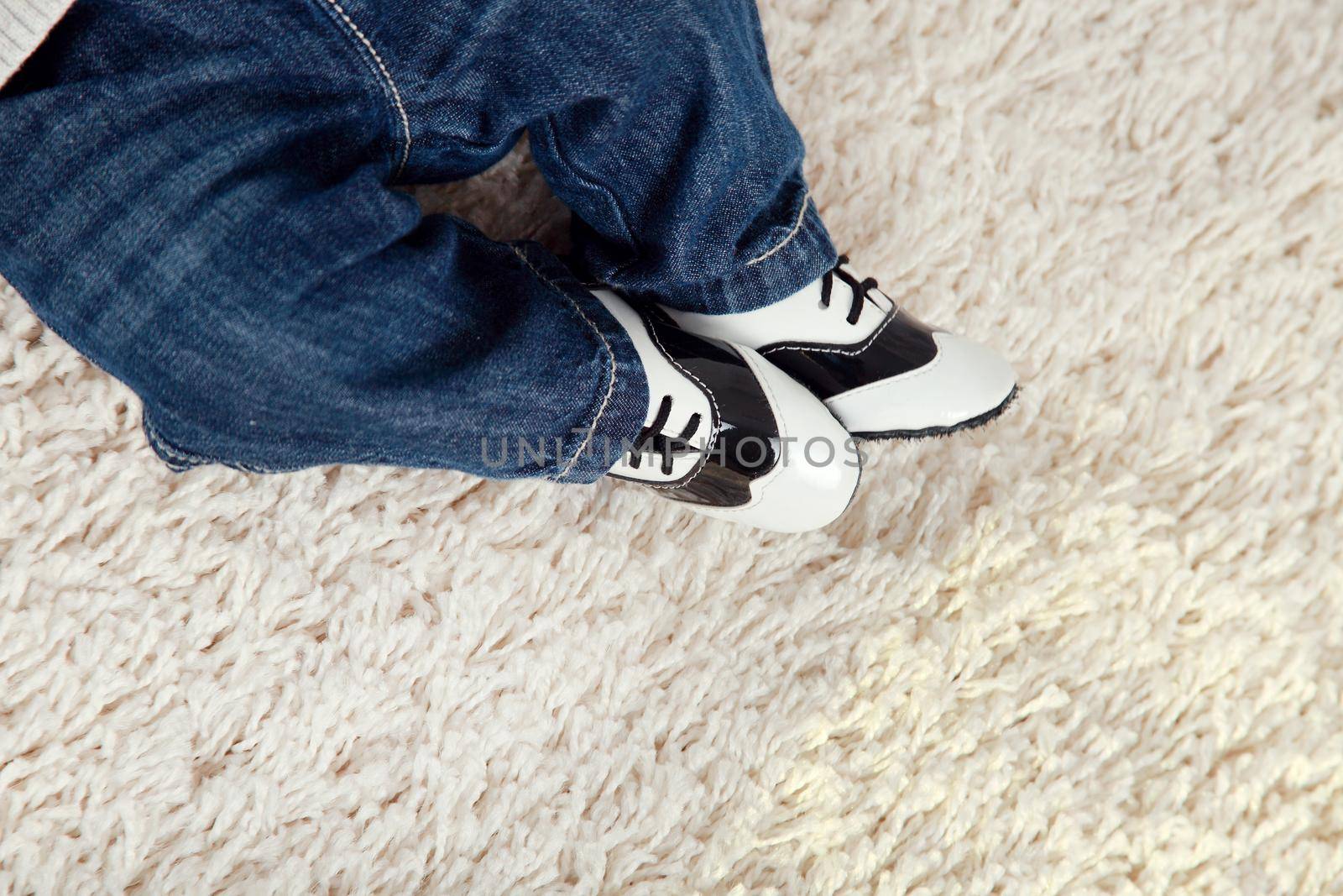Background with the child's legs in stylish blue jeans