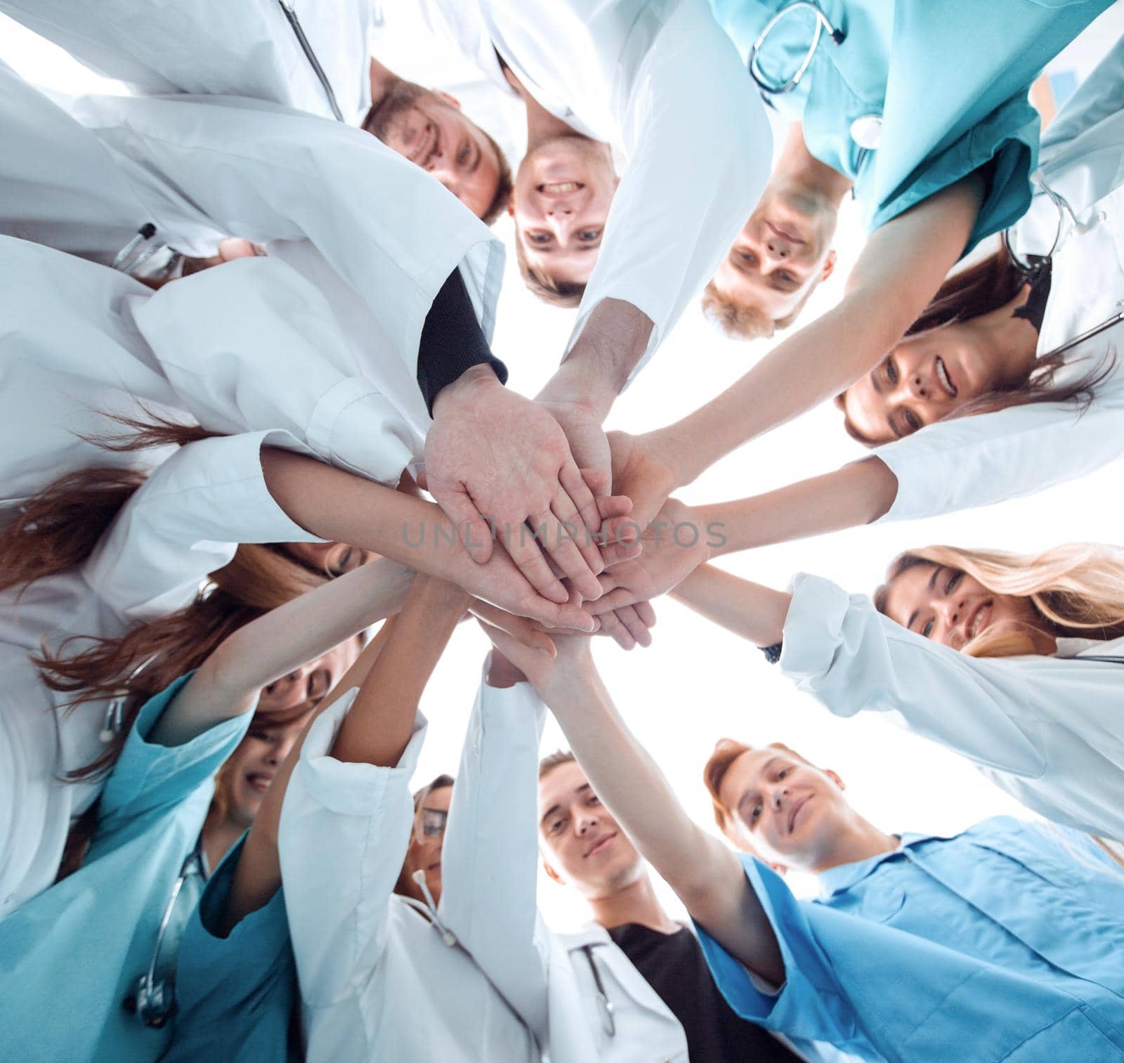 bottom view. a group of medical colleagues putting their hands together. by asdf