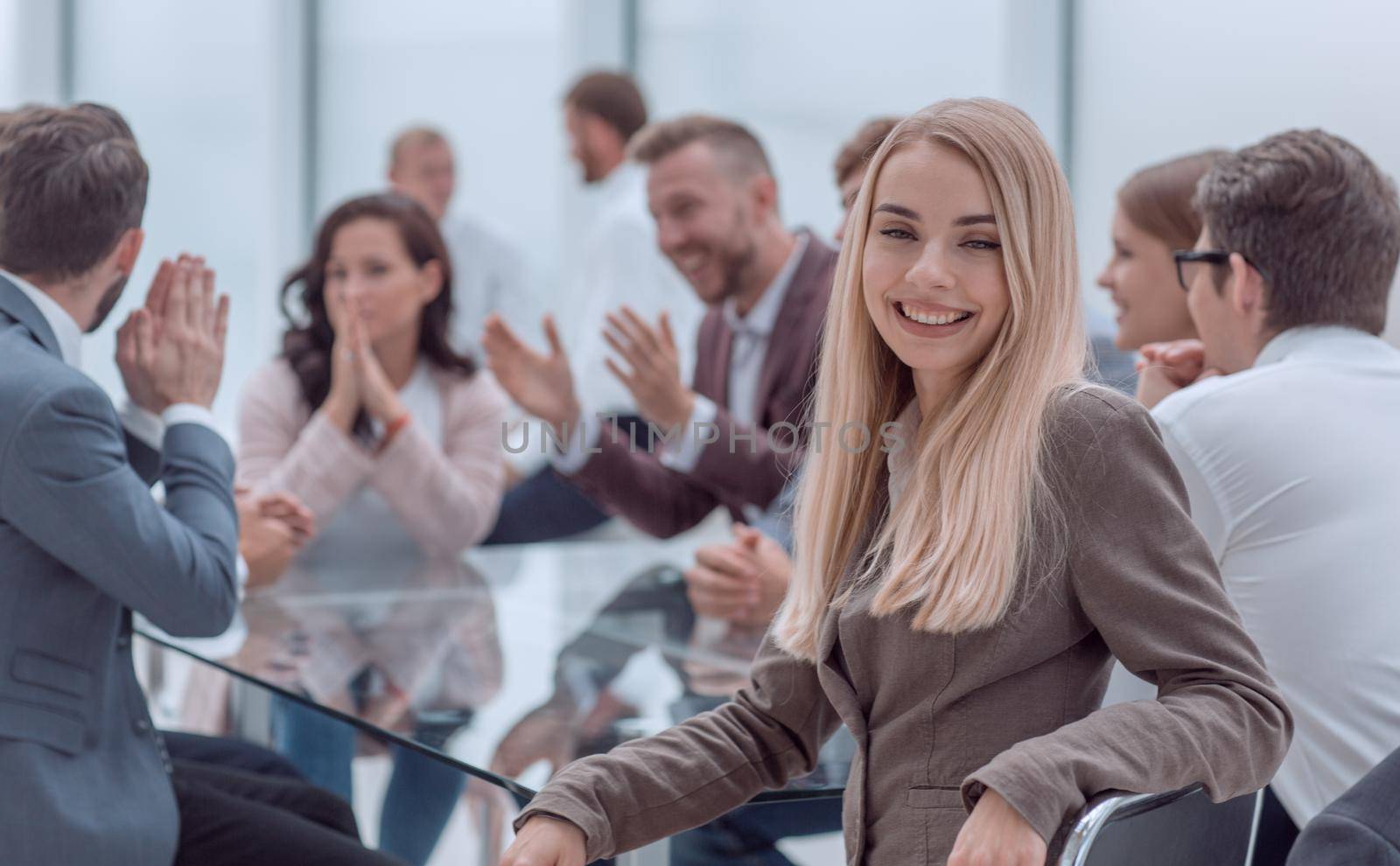 smiling young woman sitting at table in conference room by asdf