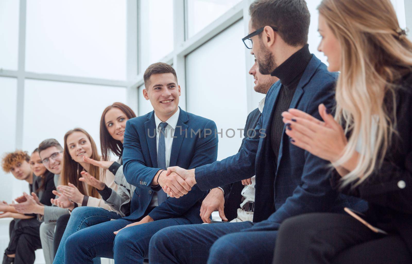 employees supporting each other with a handshake by asdf