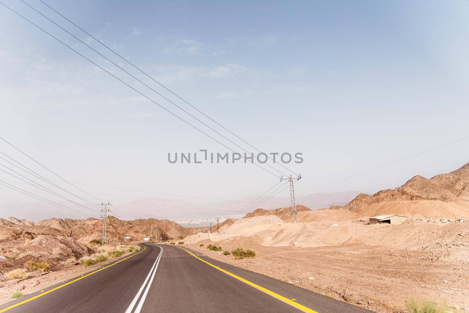 A road next to a mountainous desert landscape. Road 12 on the way to Eilat, Israel, on the Egyptian border. Mountains in different and varied sand colors. by avirozen