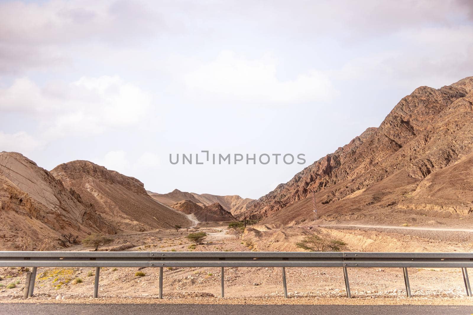 A road next to a mountainous desert landscape. Road 12 on the way to Eilat, Israel, on the Egyptian border. Mountains in different and varied sand colors. by avirozen