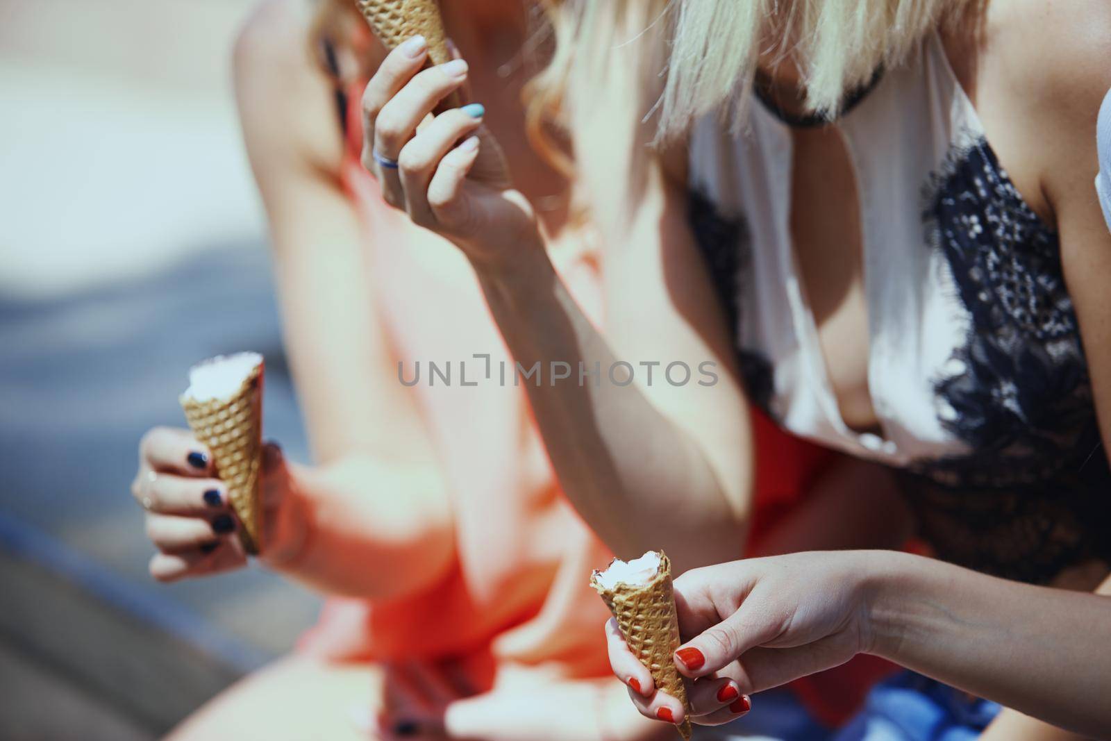 Hands of girlfriends eating ice cream by Novic