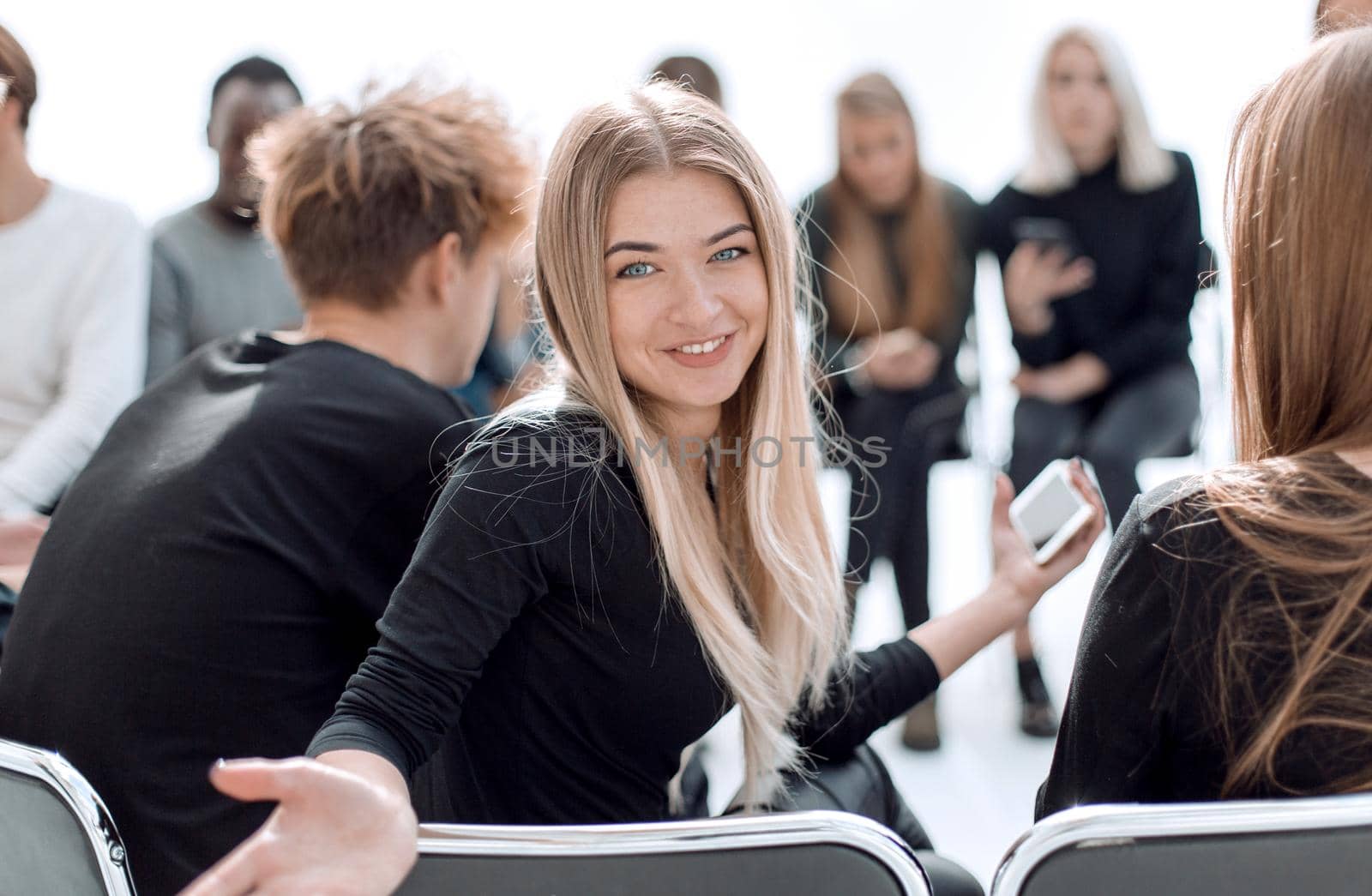 close up. cute young woman sitting in a circle of friends