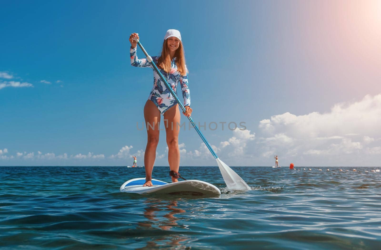 SUP Stand up paddle board. Young woman sailing on beautiful calm sea with crystal clear water. The concept of an summer holidays vacation travel, relax, active and healthy life in harmony with nature
