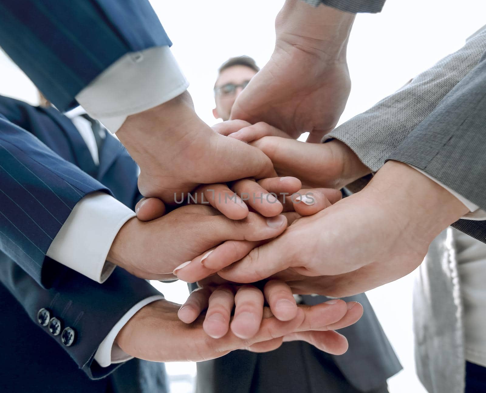 business people folding their hands together. by asdf