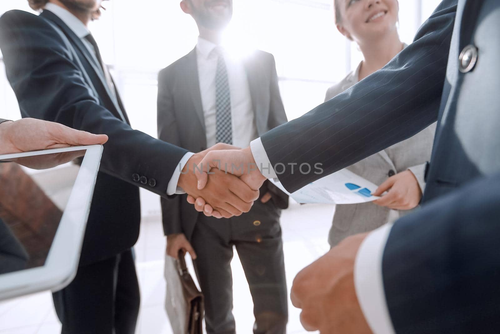 employees look at the handshake business partners by asdf