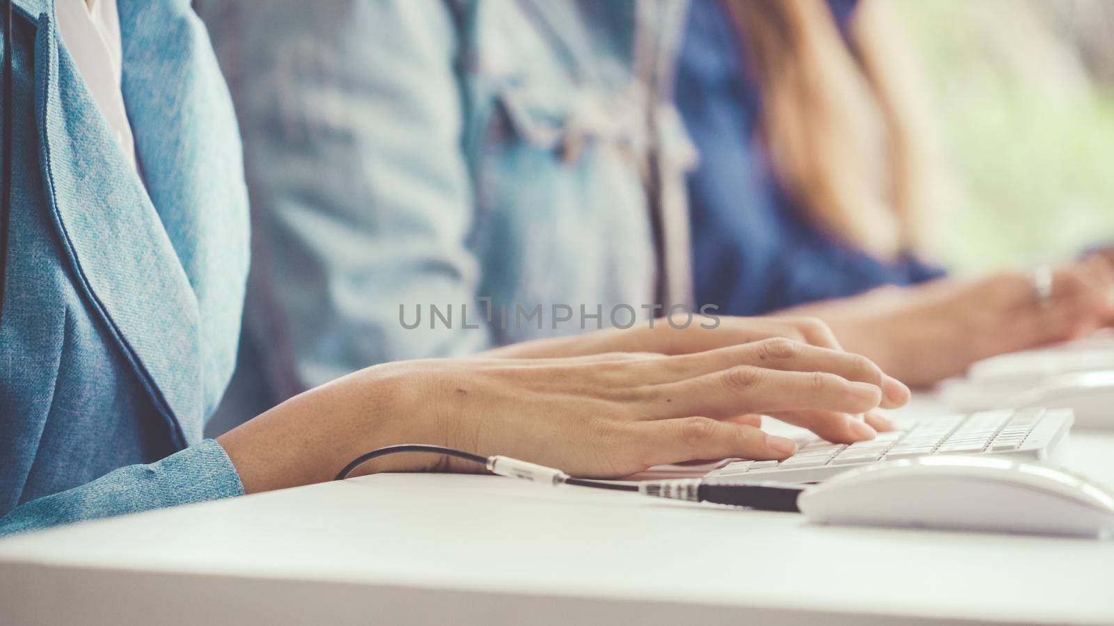 Close up shot of businesswoman hand typing and working on desktop computer on the office desk. Business communication and workplace concept.