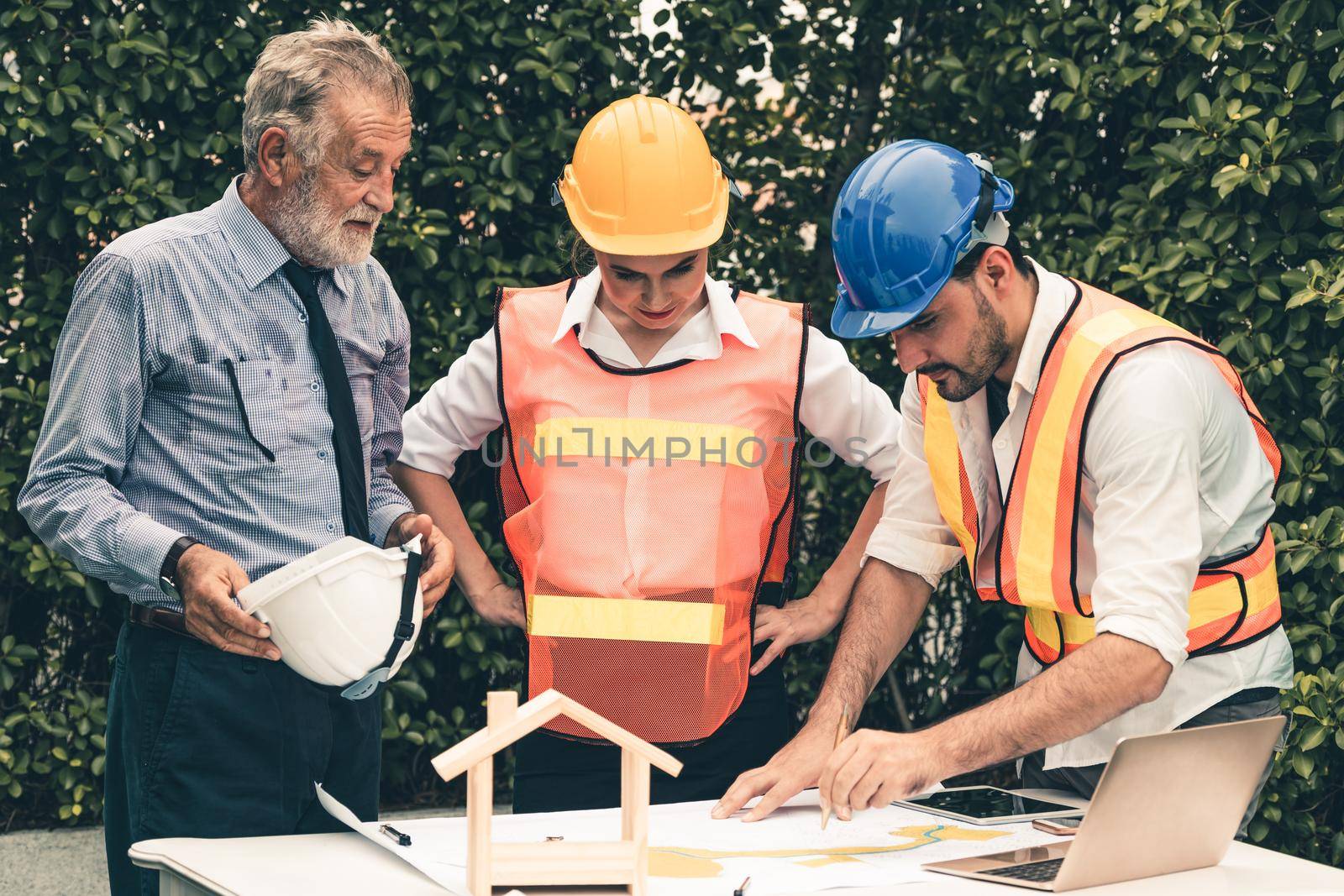 Engineer, architect and business man working on the engineering project at construction site. House building concept.