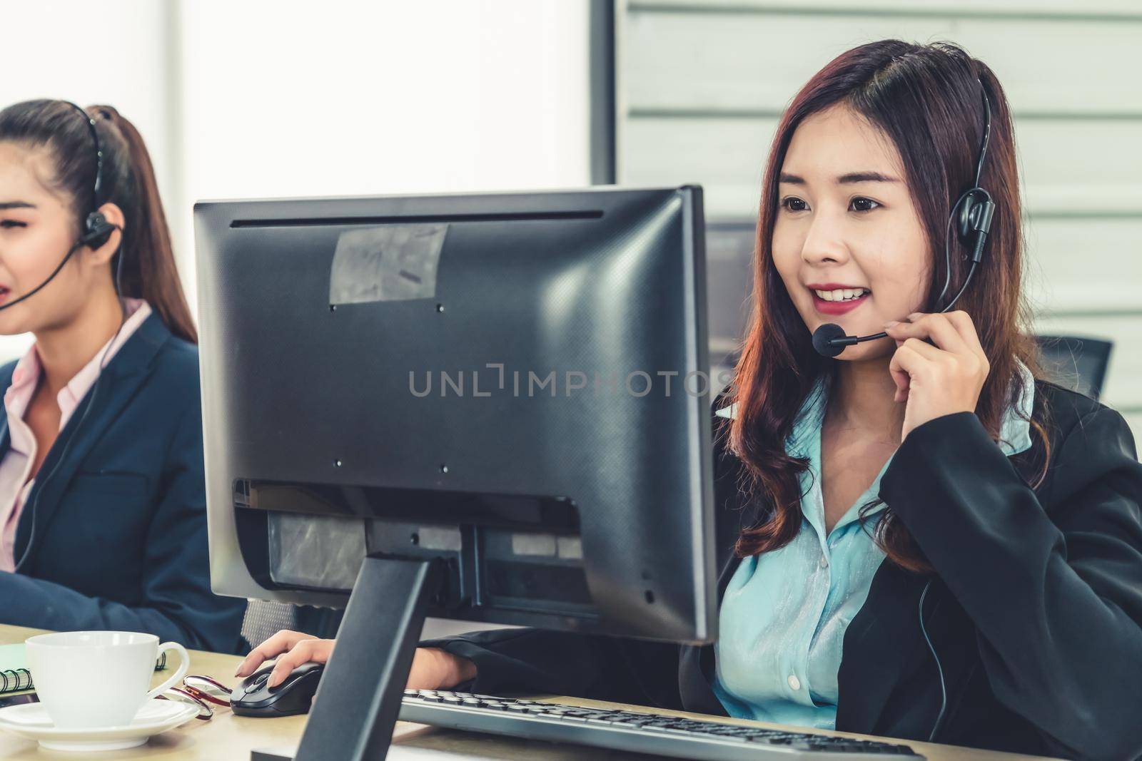 Business people wearing headset working in office to support remote customer or colleague. Call center, telemarketing, customer support agent provide service on telephone video conference call.