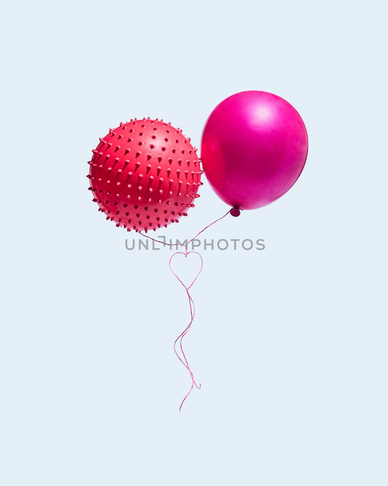 Two balloons with ropes that form a heart isolated on a blue background. The concept of Valentine's Day and love. by Nemo_Family