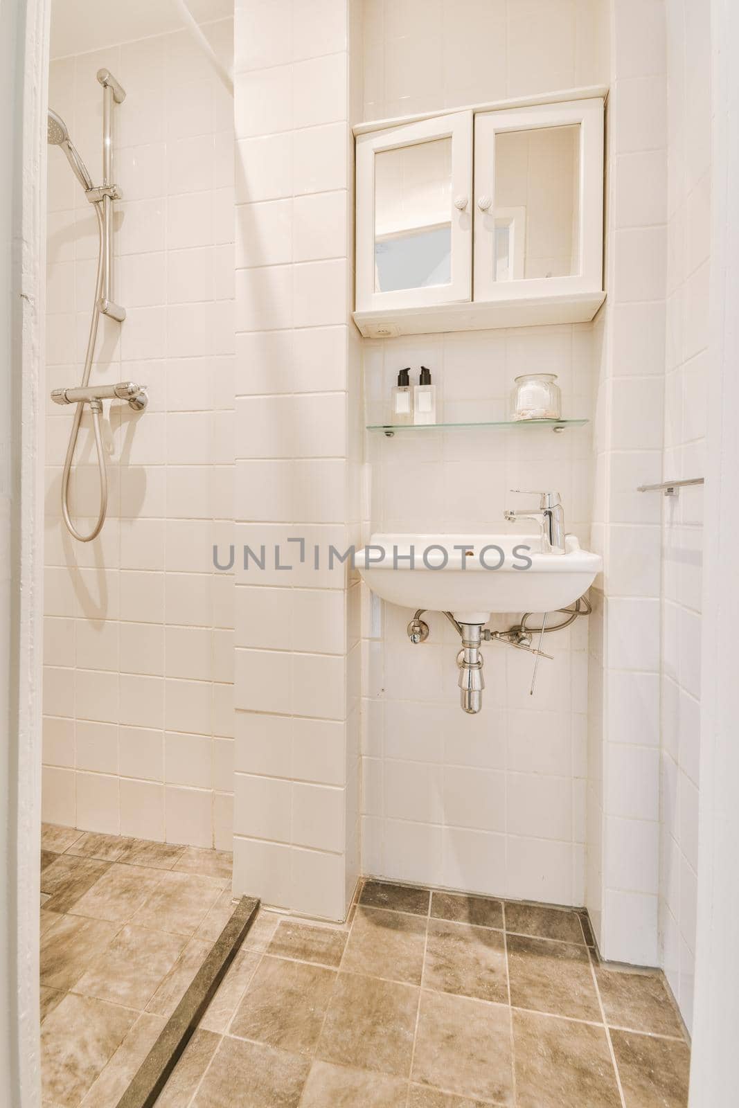 Interior of modern bathroom with shower box and sink by casamedia