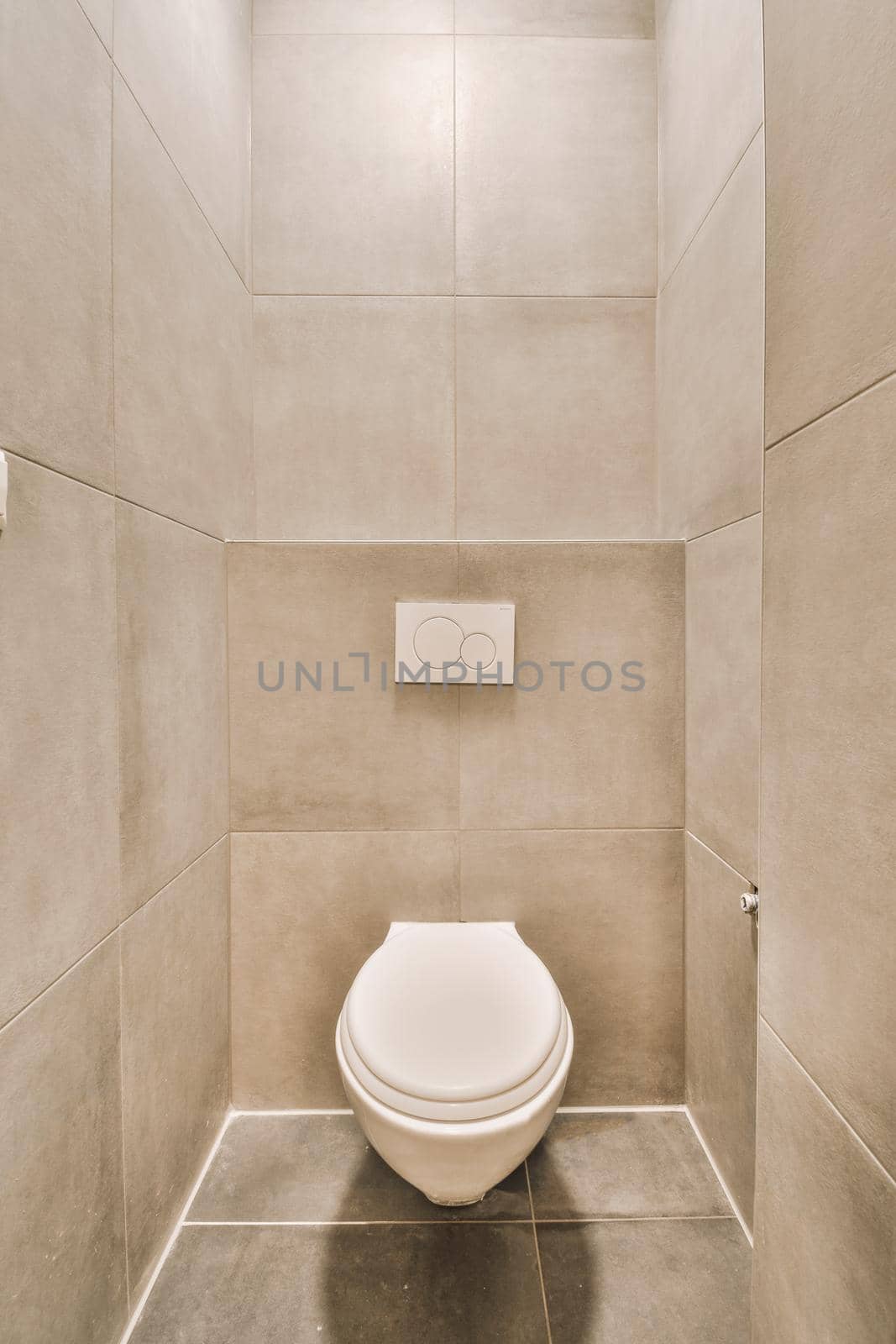 Interior of narrow restroom with sink and wall hung toilet with white walls and checkered floor