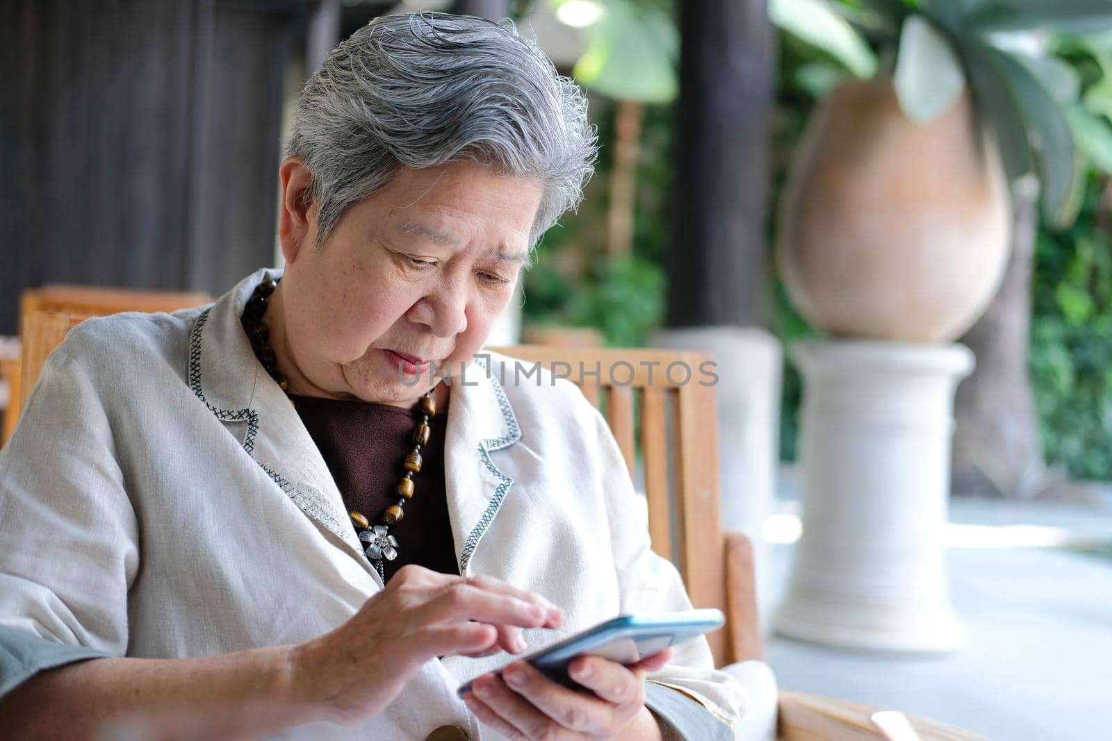 asian elder senior woman using mobile smart phone. elderly female holding cellphone. mature retirement lifestyle