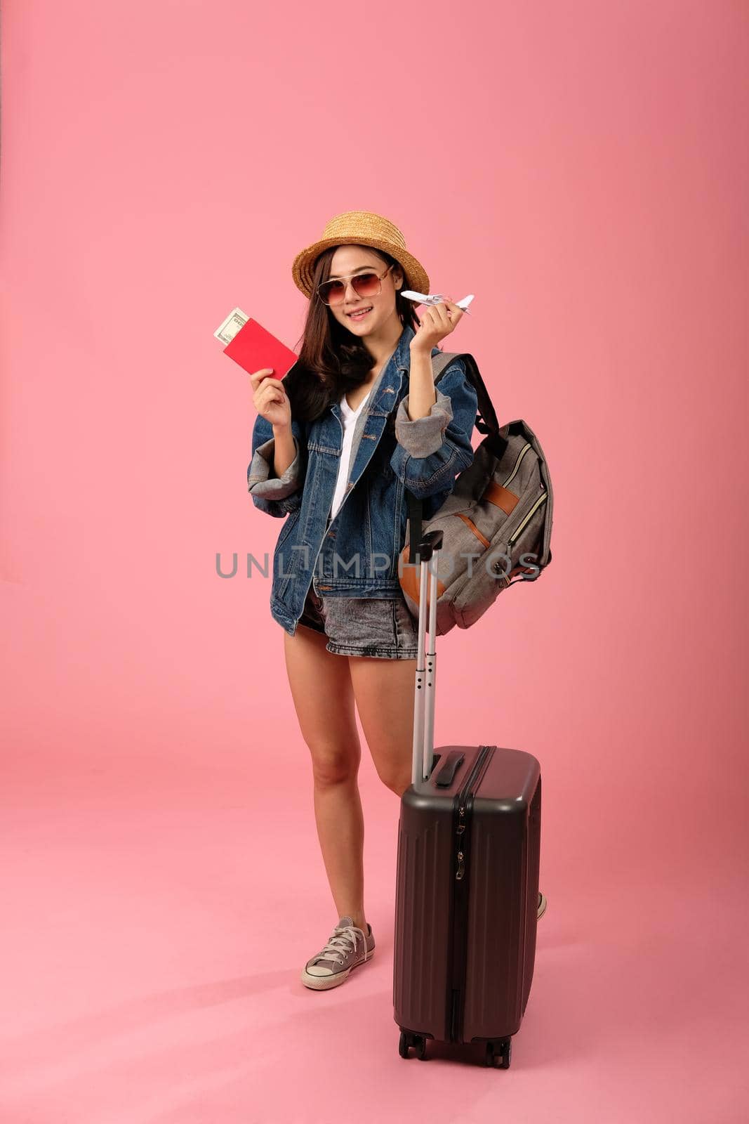 young asian woman backpacker traveler with passport & money. journey trip travel. studio shot