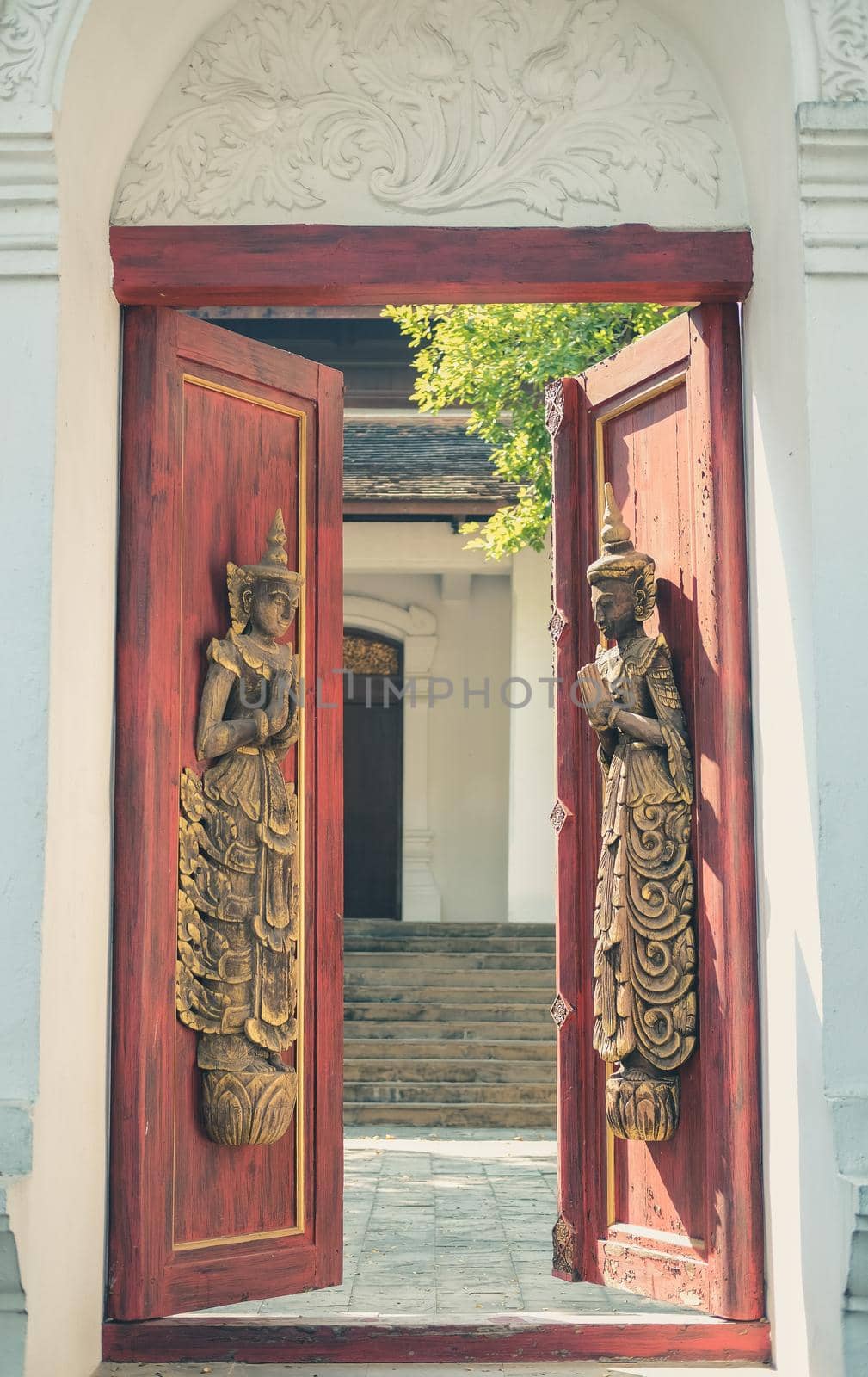 old vintage wooden door arch with asian angel sculpture
